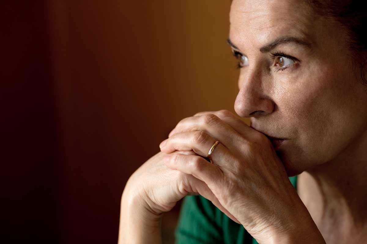 a woman contemplates her symptoms, wondering if she needs to see a dr