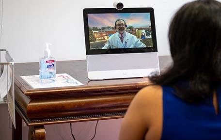 Woman talks to doctor through tablet and web camera