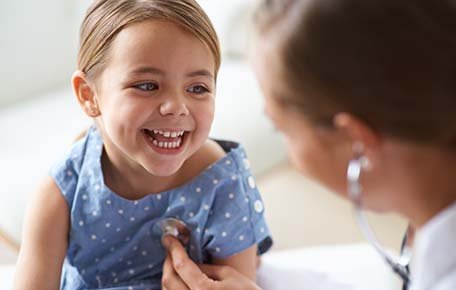 A little girl smiles as she interacts with a provider