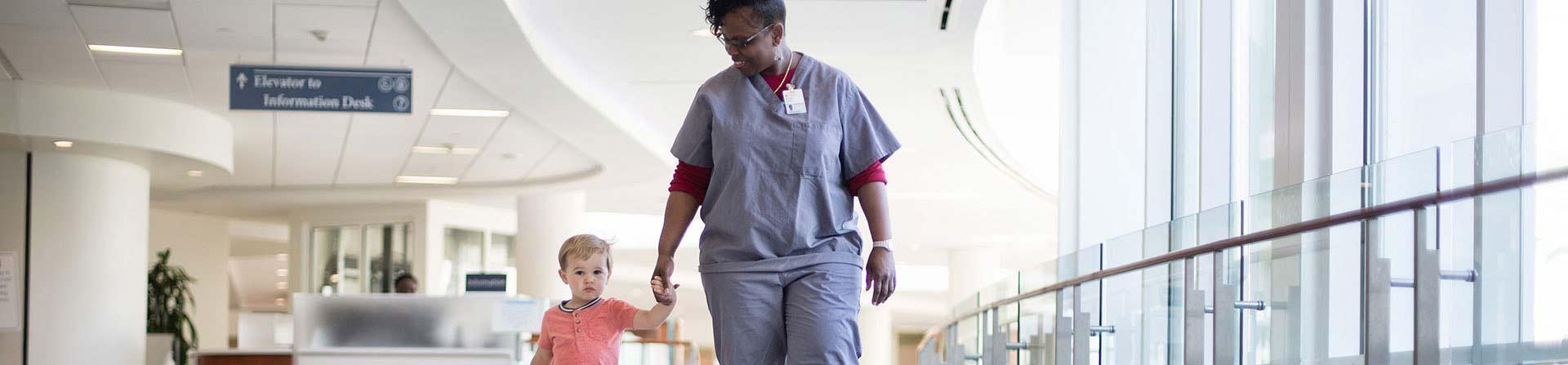 A nurse holding a child's hand