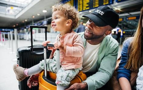 Dad and young child sit together at the airport