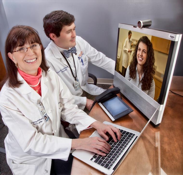 2 doctors consult with a specialist through a computer