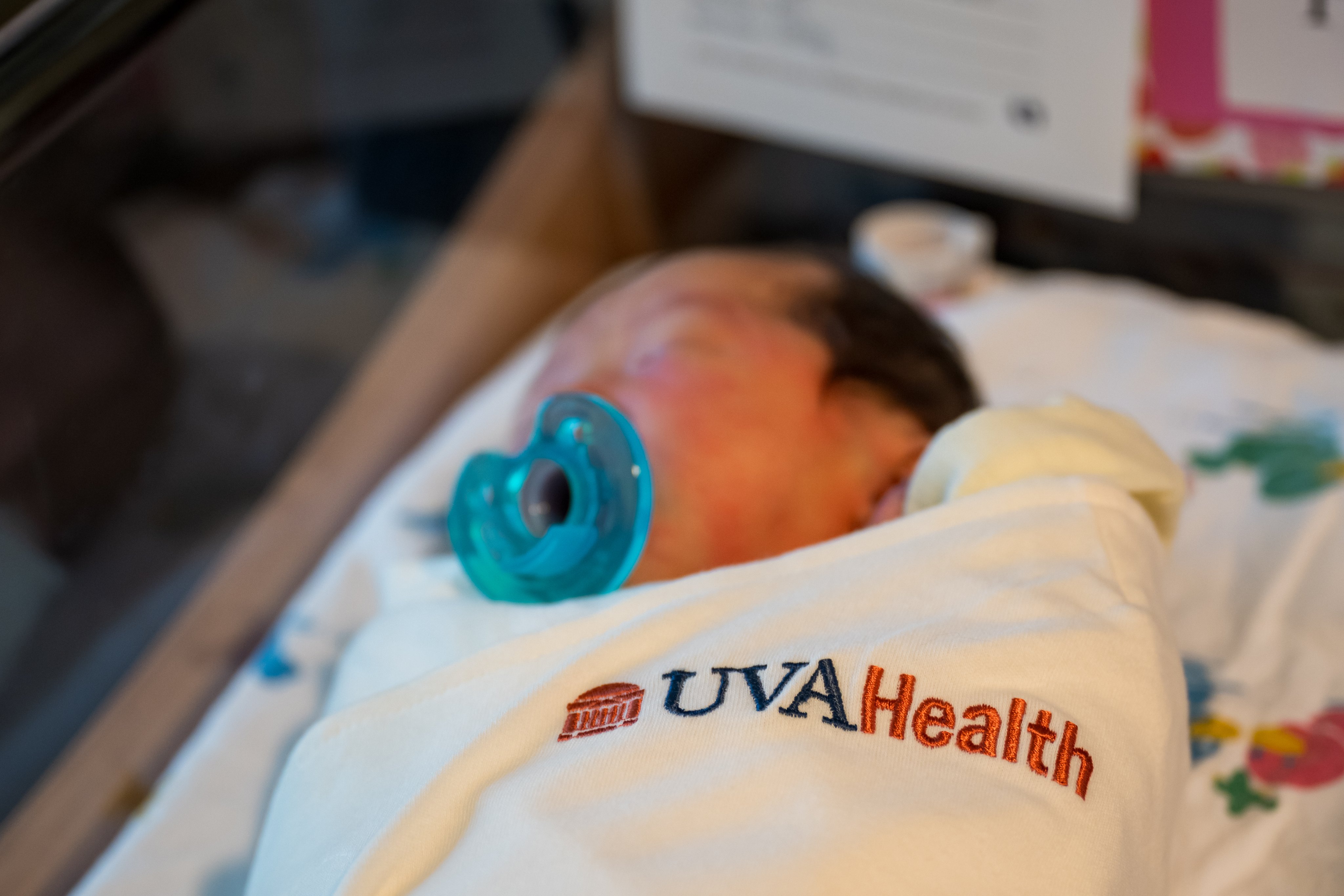Newborn baby wrapped in UVA Health swaddle