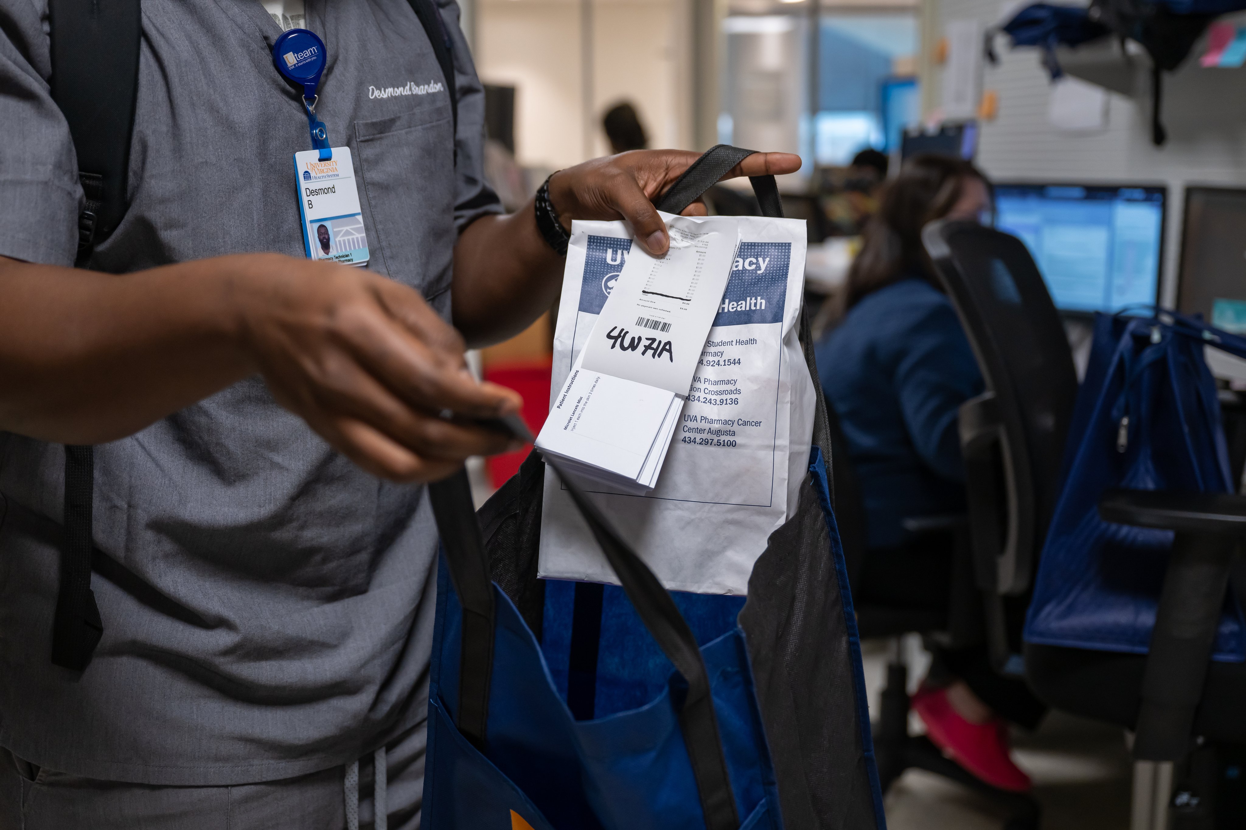 Pharmacist packs bags with prescriptions