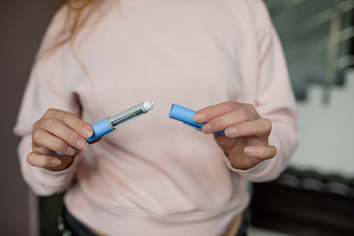 A woman holding a GLP-1 injector