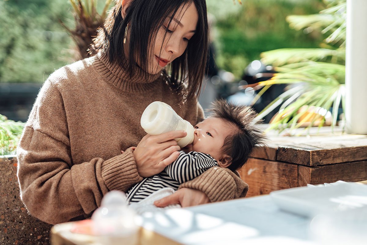 Mom feeds her baby bottle of formula