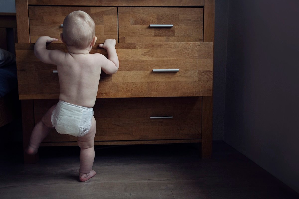 Baby opening drawers as they explore home