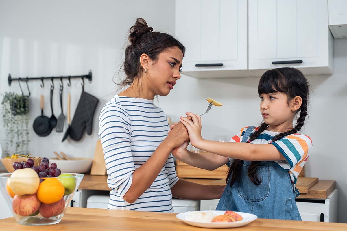 Parent tries to offer child food on fork