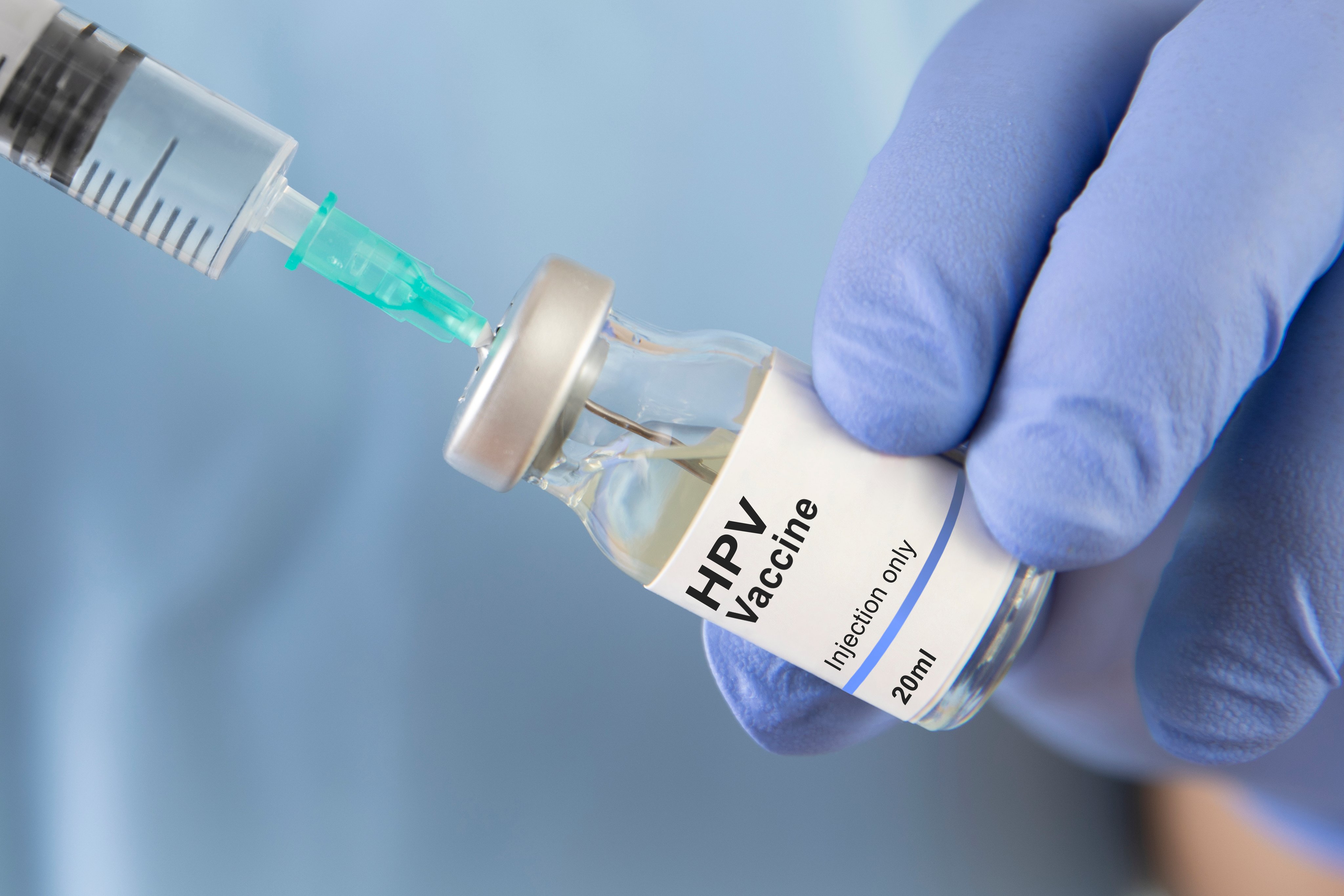 Vial labeled HPV vaccine is drawn into syringe