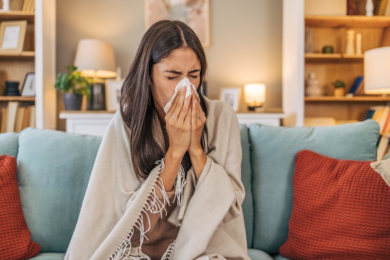 Photo of a woman blowing her nose.