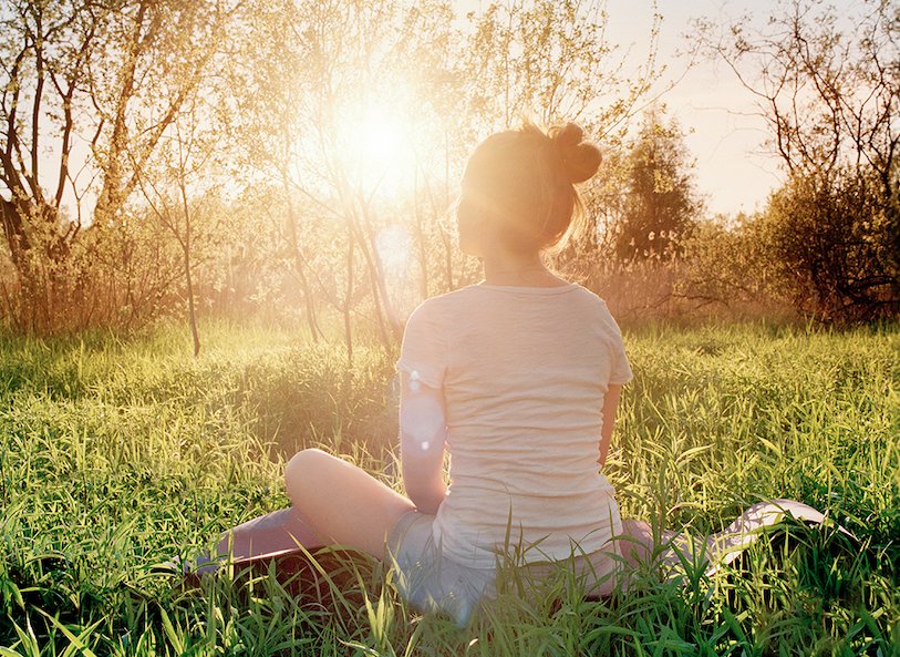 Young woman sitting outside in the sunlight