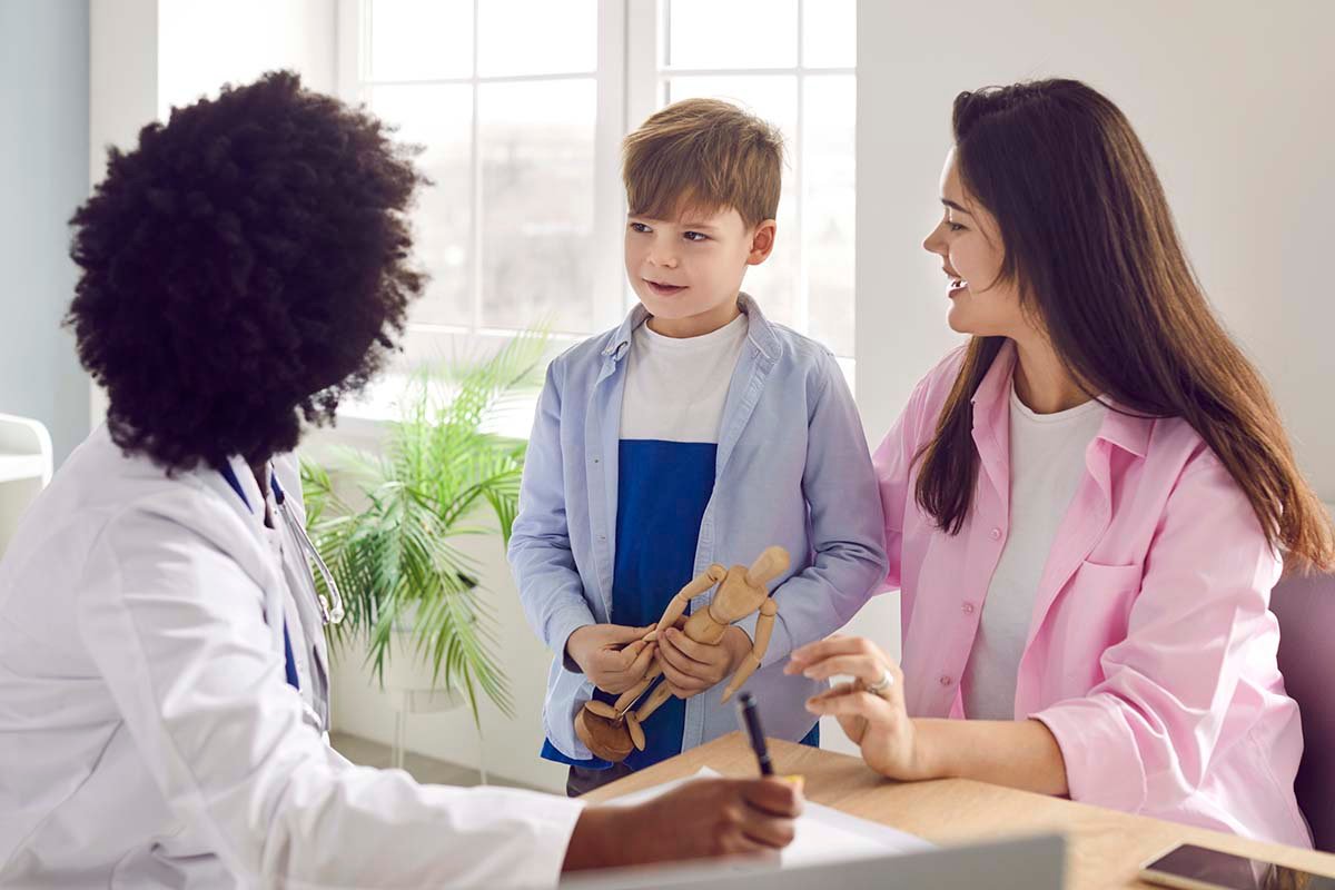A mom and her son talk to a doctor