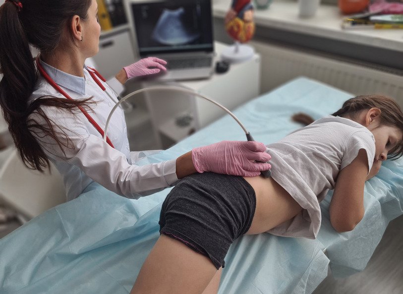 Doctor looks at young girl's kidney on ultrasound