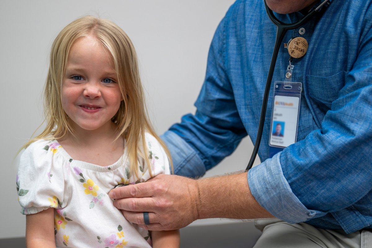 Pediatrician listens to patient's heart with stethoscope 