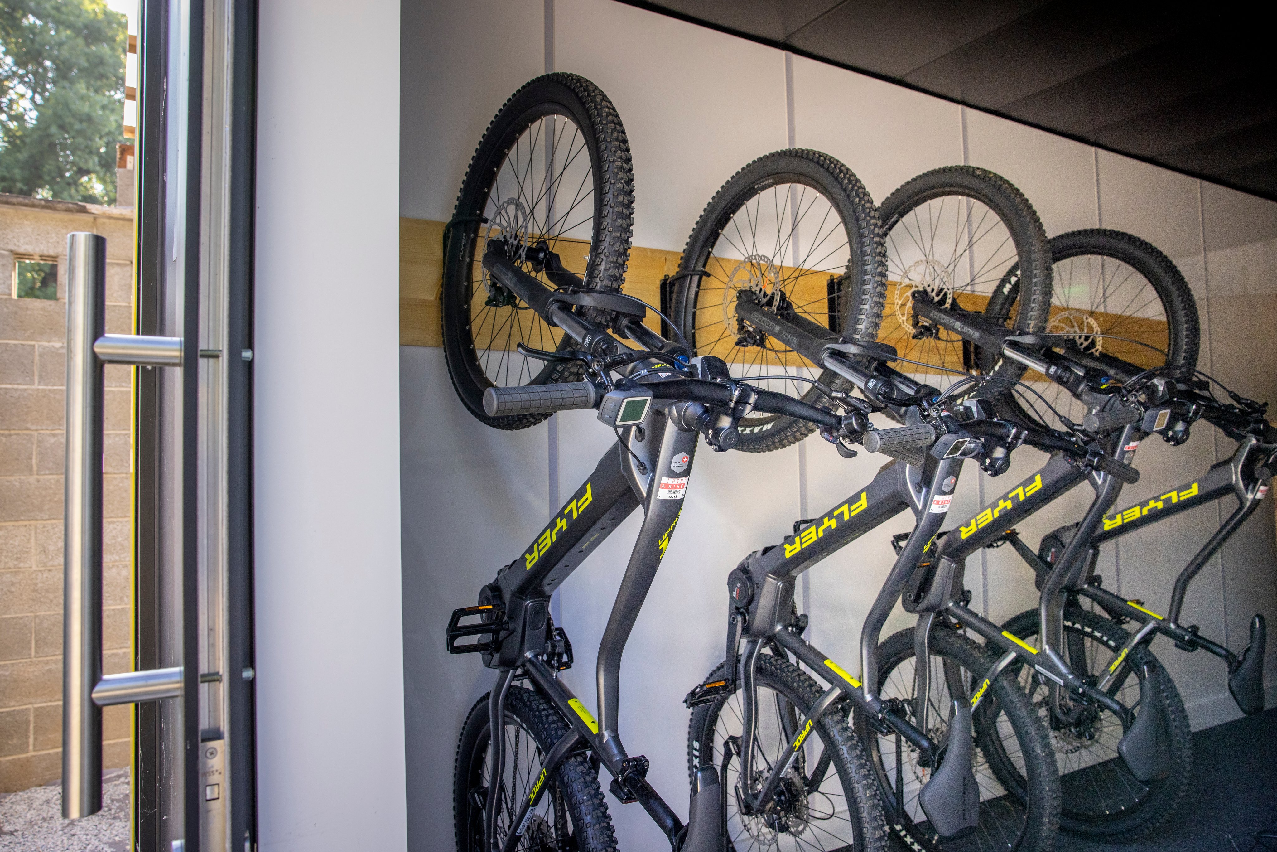 Quatre vélos électriques tout terrain sont accrochés à un porte-vélos. 