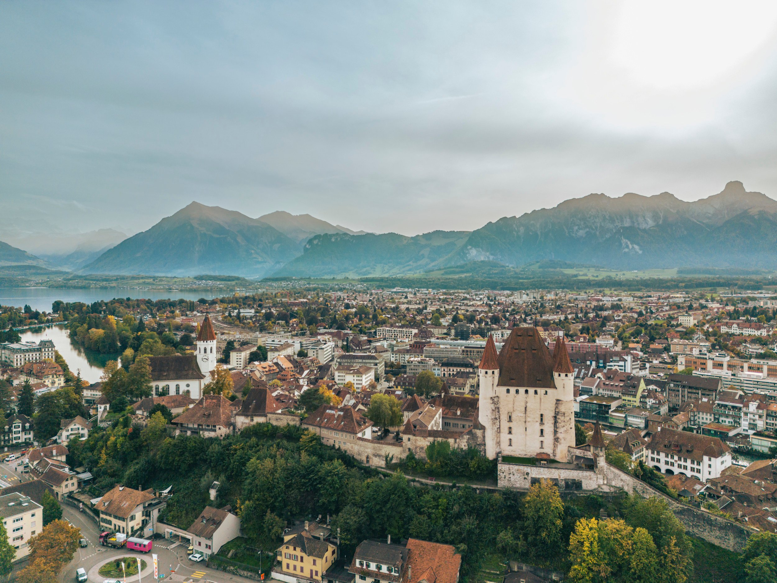 Foto da drone del centro storico di Thun, con le montagne sullo sfondo.