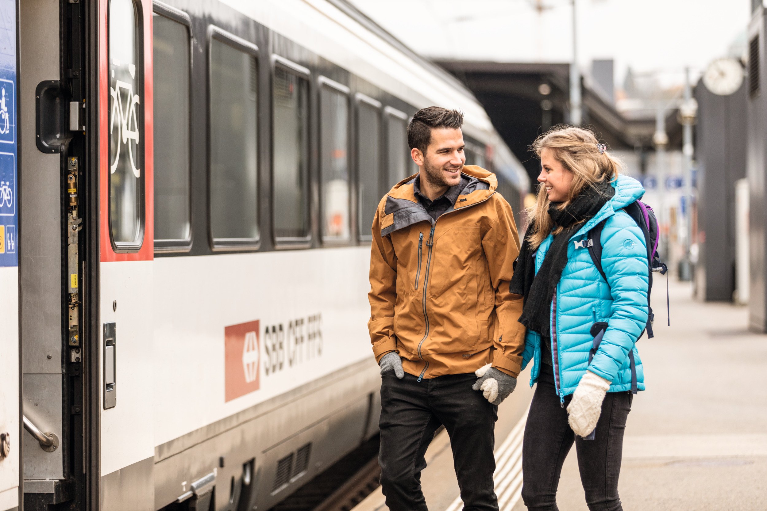 Couple montant dans le train CFF pour les vacances d'hiver.