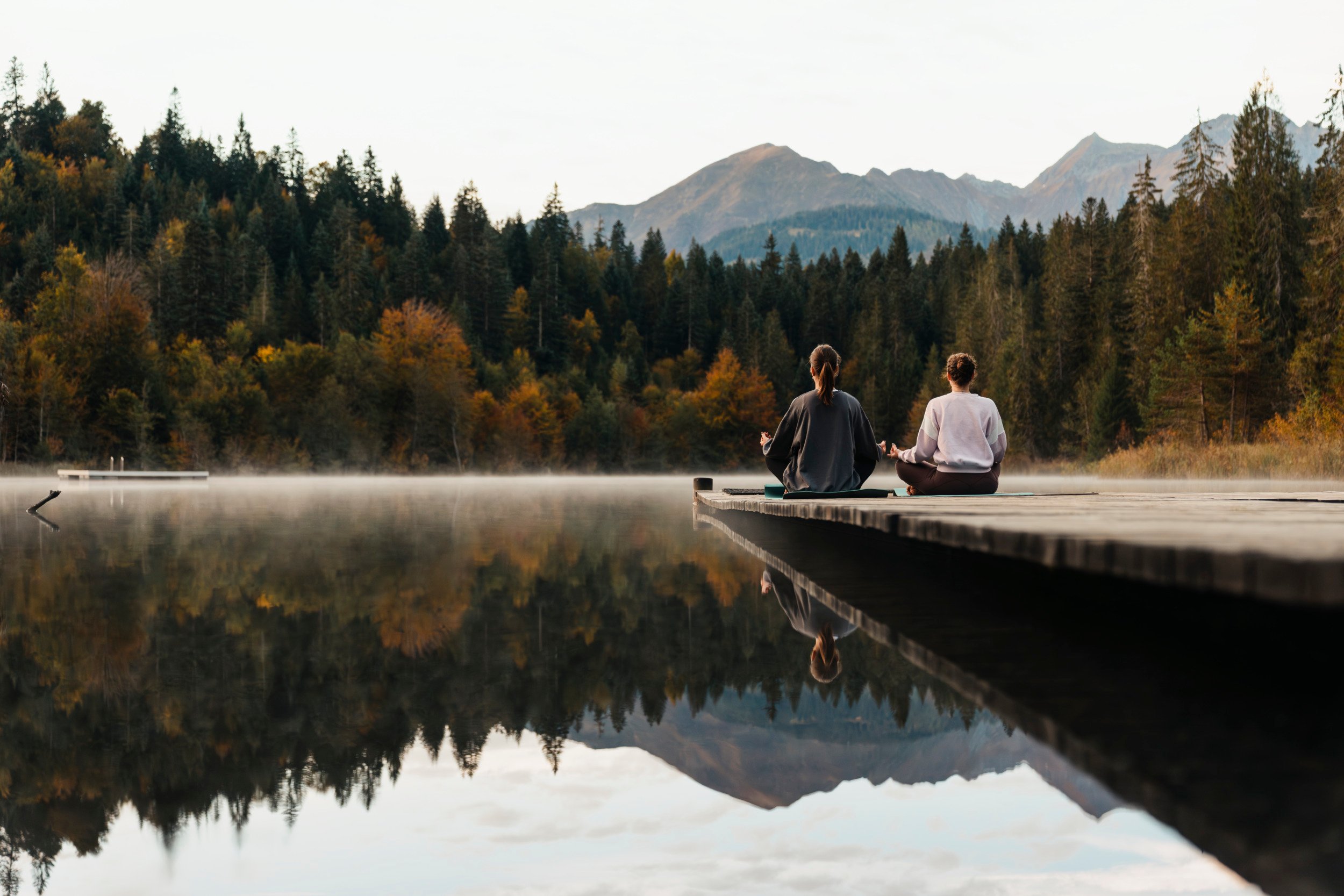 Due donne fanno yoga sul lago Cresta a Laax, nei Grigioni.
