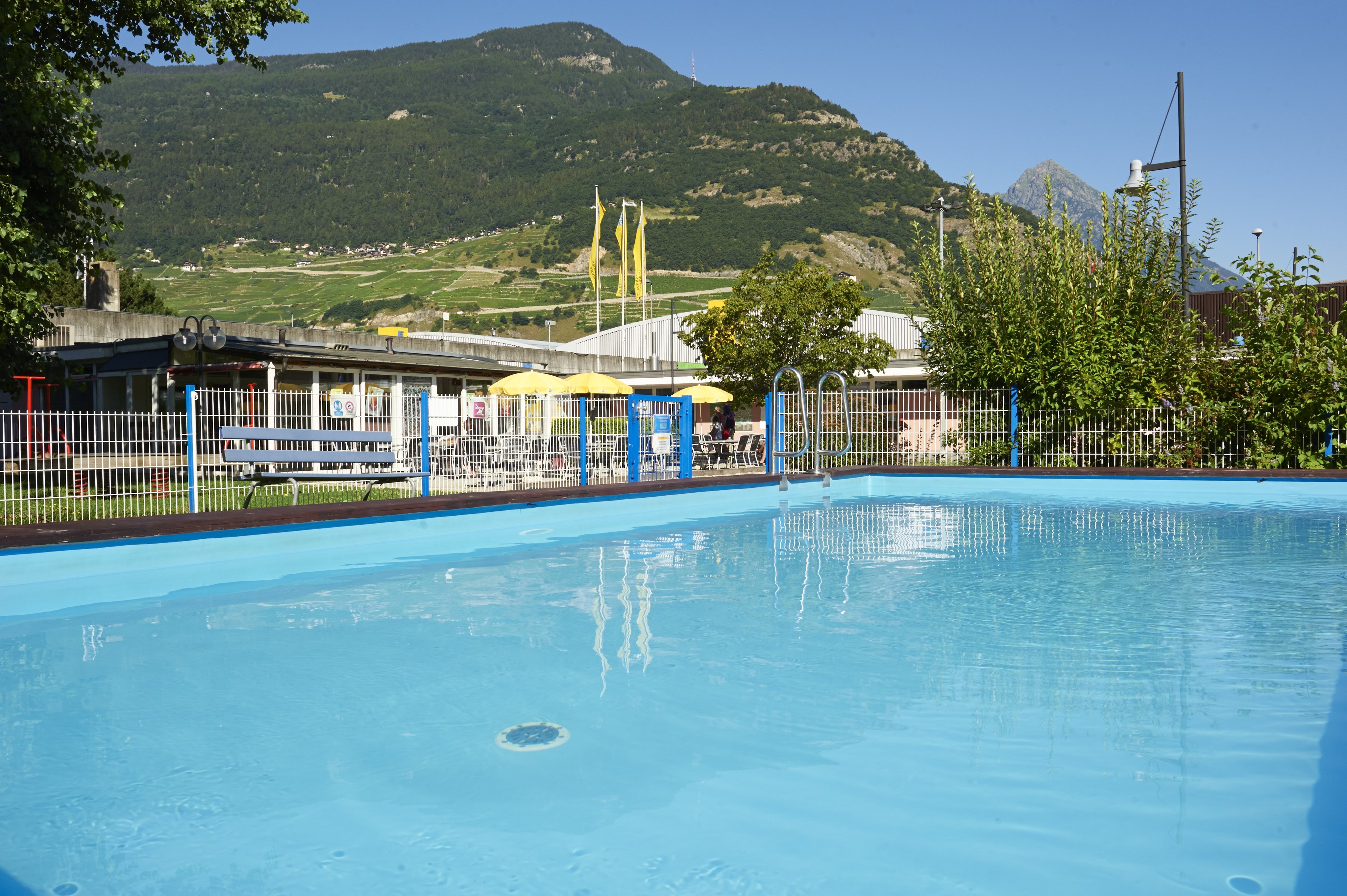 Une piscine sur un camping avec une montagne en arrière-plan.