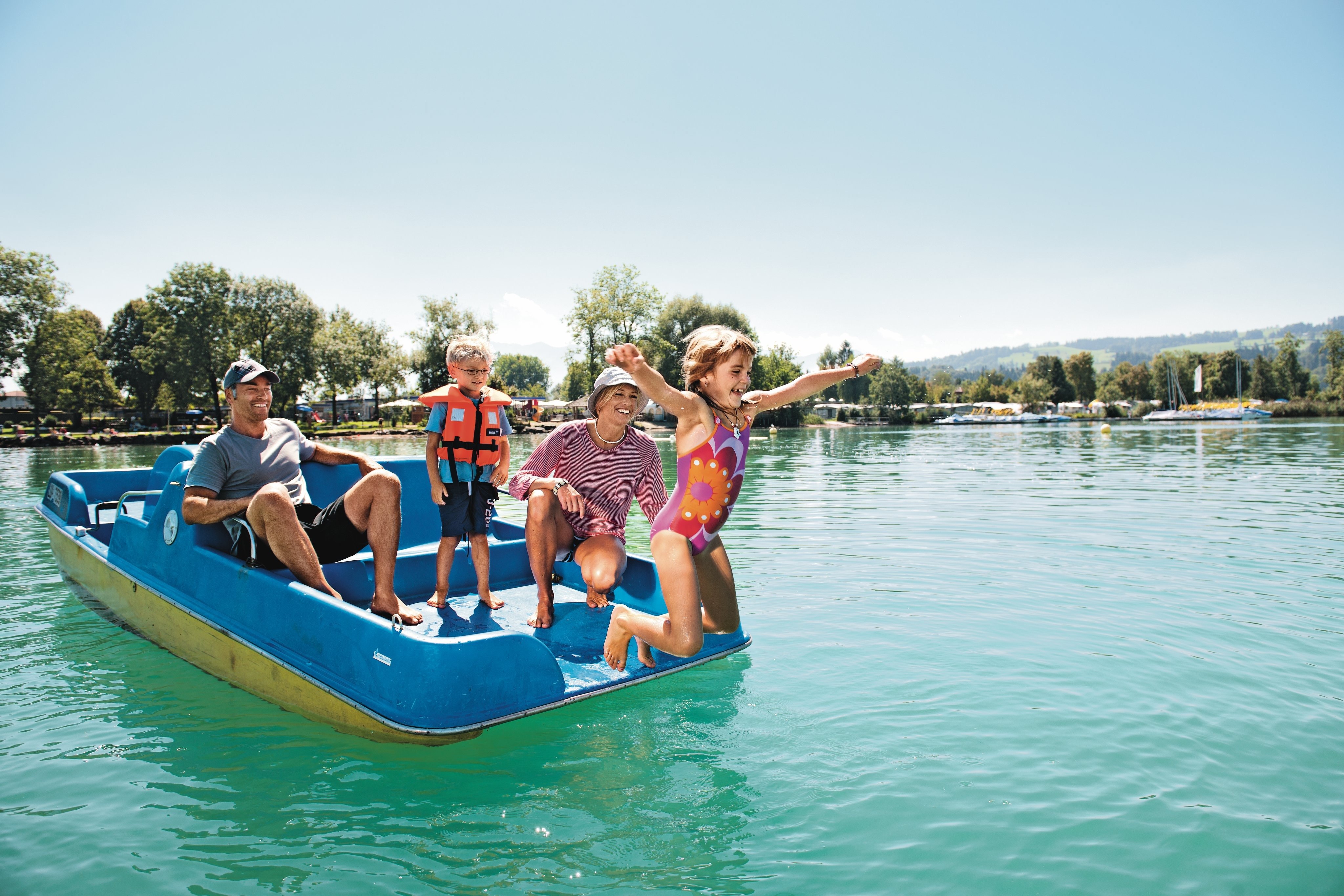 La famille profite du beau temps sur le pédalo.