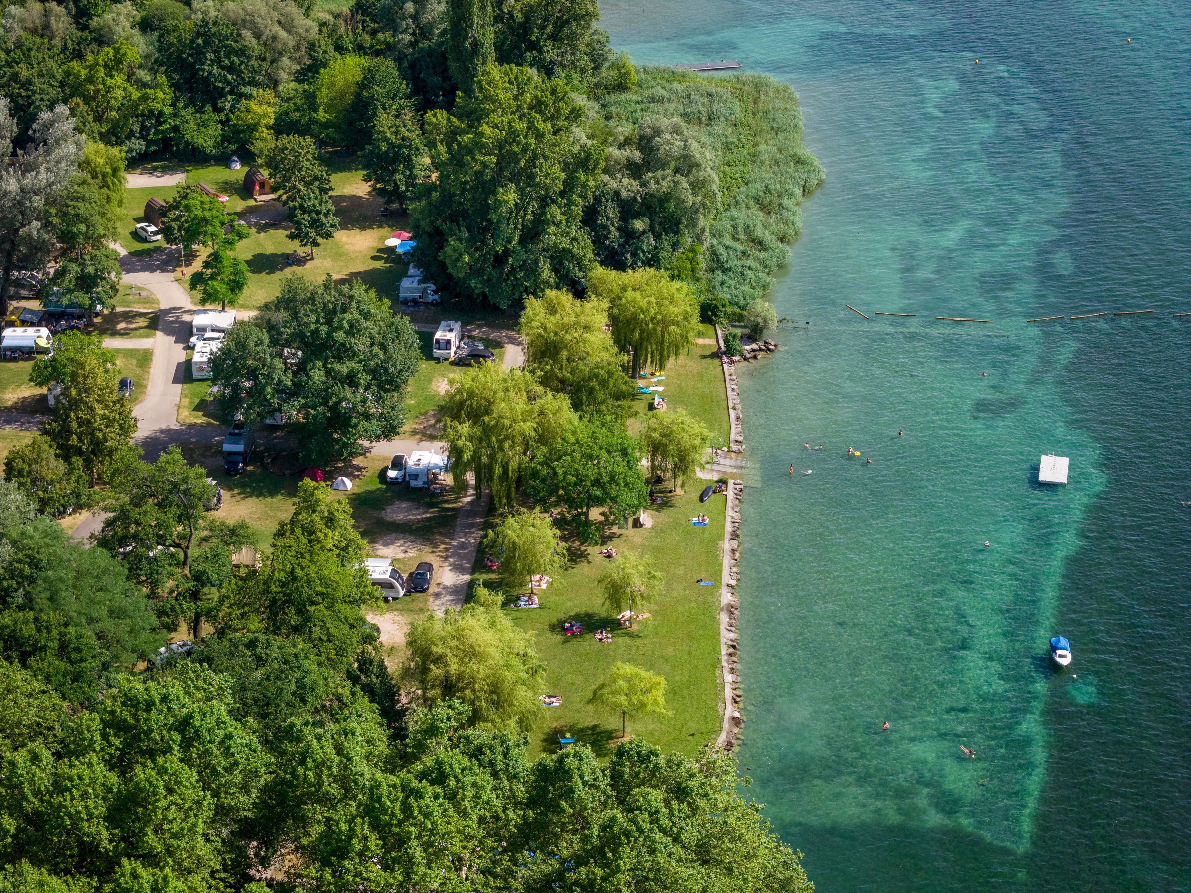 Drone photo of a campsite right by a lake.