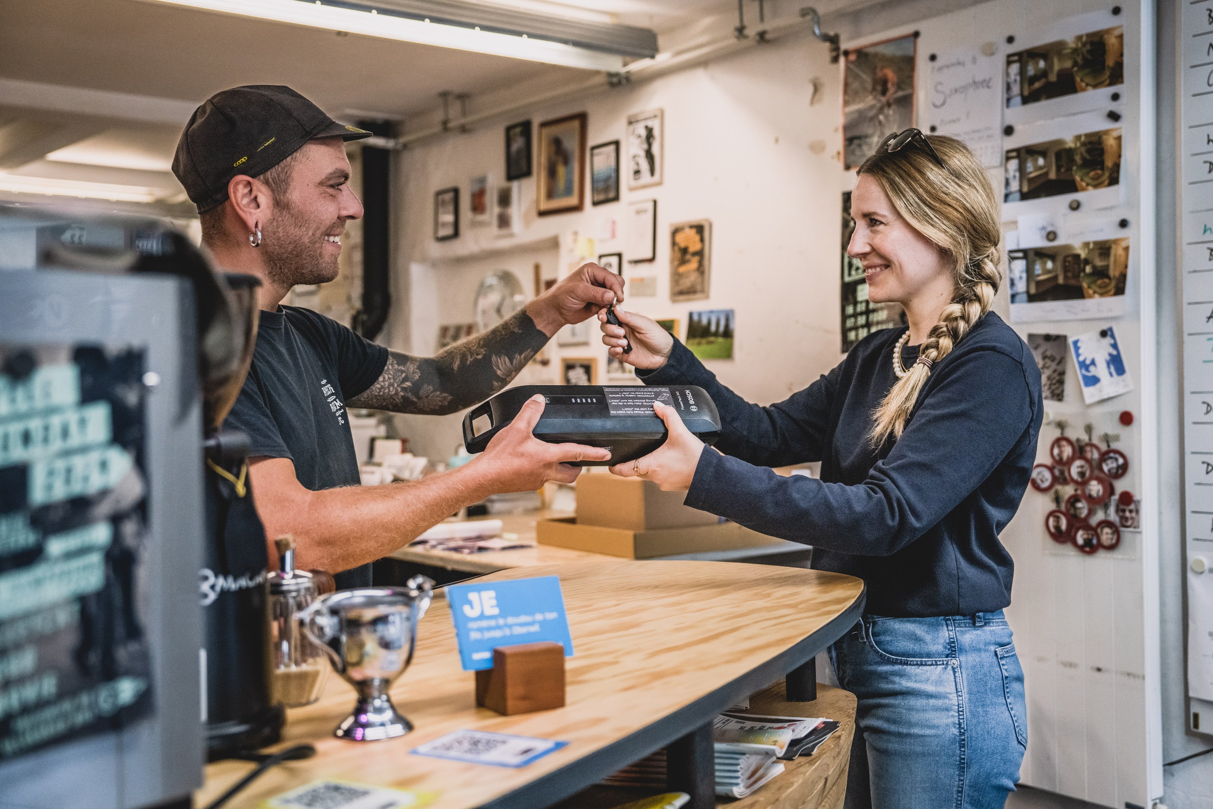 Un homme donne à une femme une batterie pour un vélo électrique.