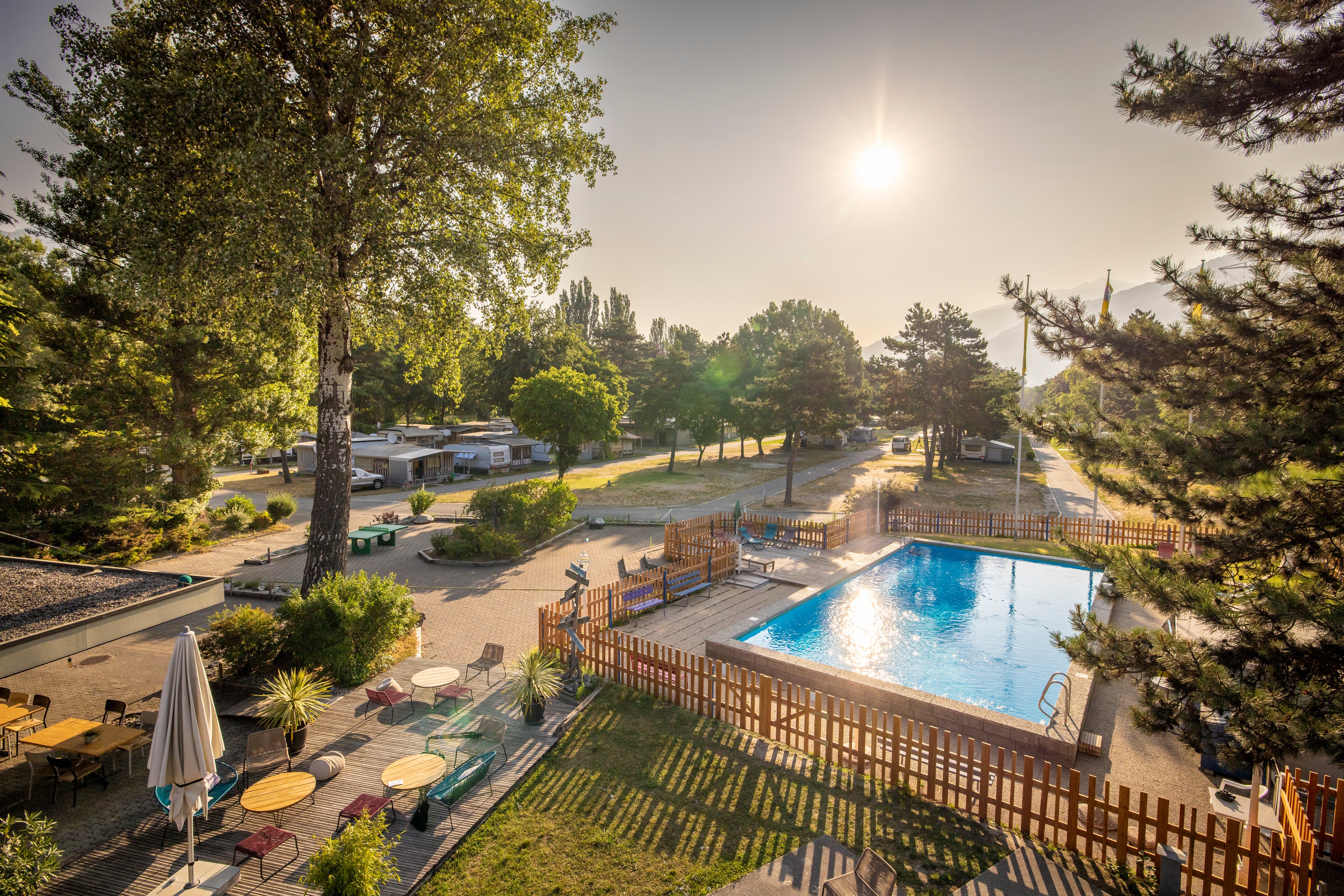 TCS Camping Sion - situation ensoleillée avec lac de baignade, camp de surf et vue sur les Alpes
