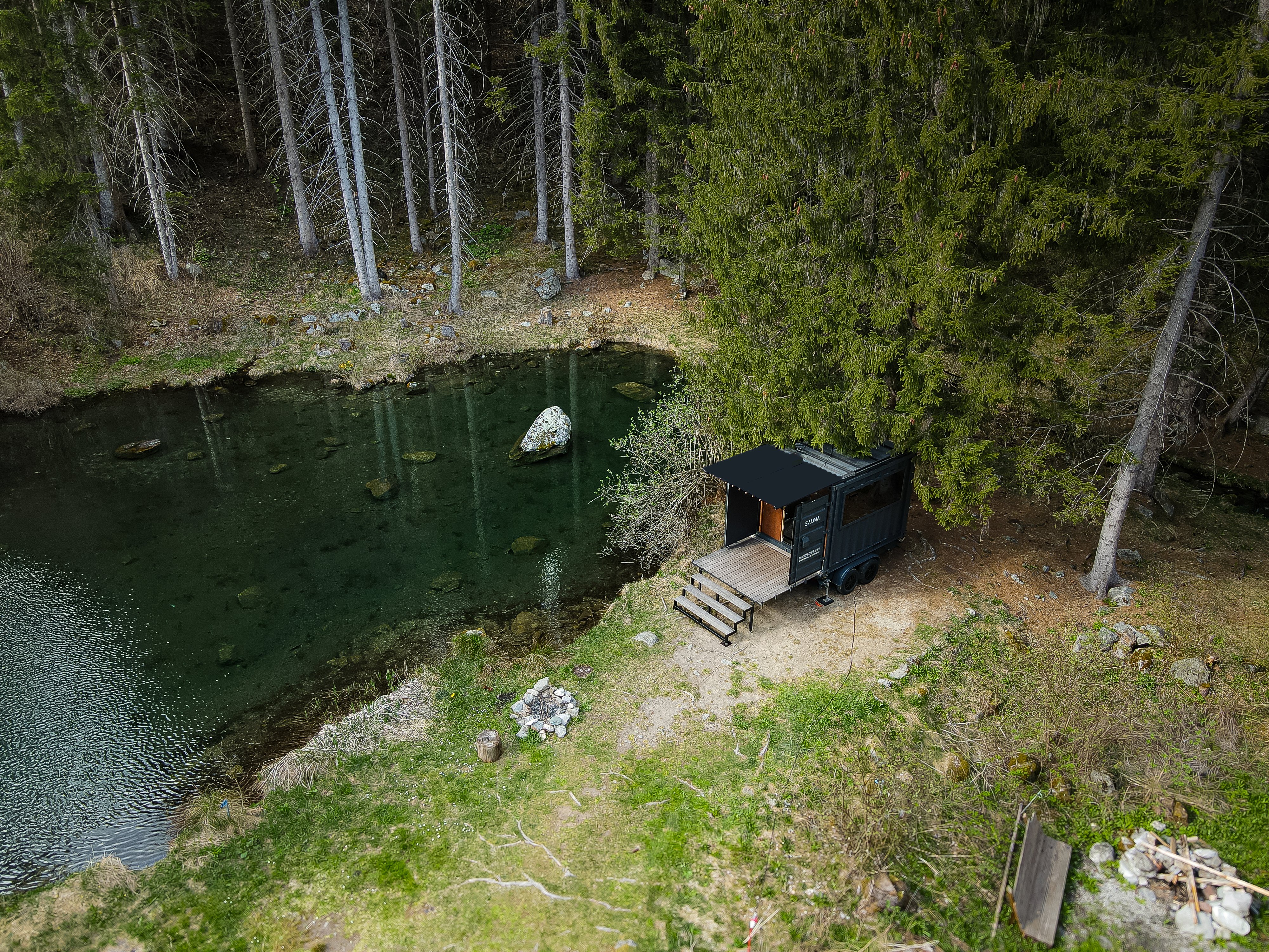 Sauna next to a small lake in the forest.
