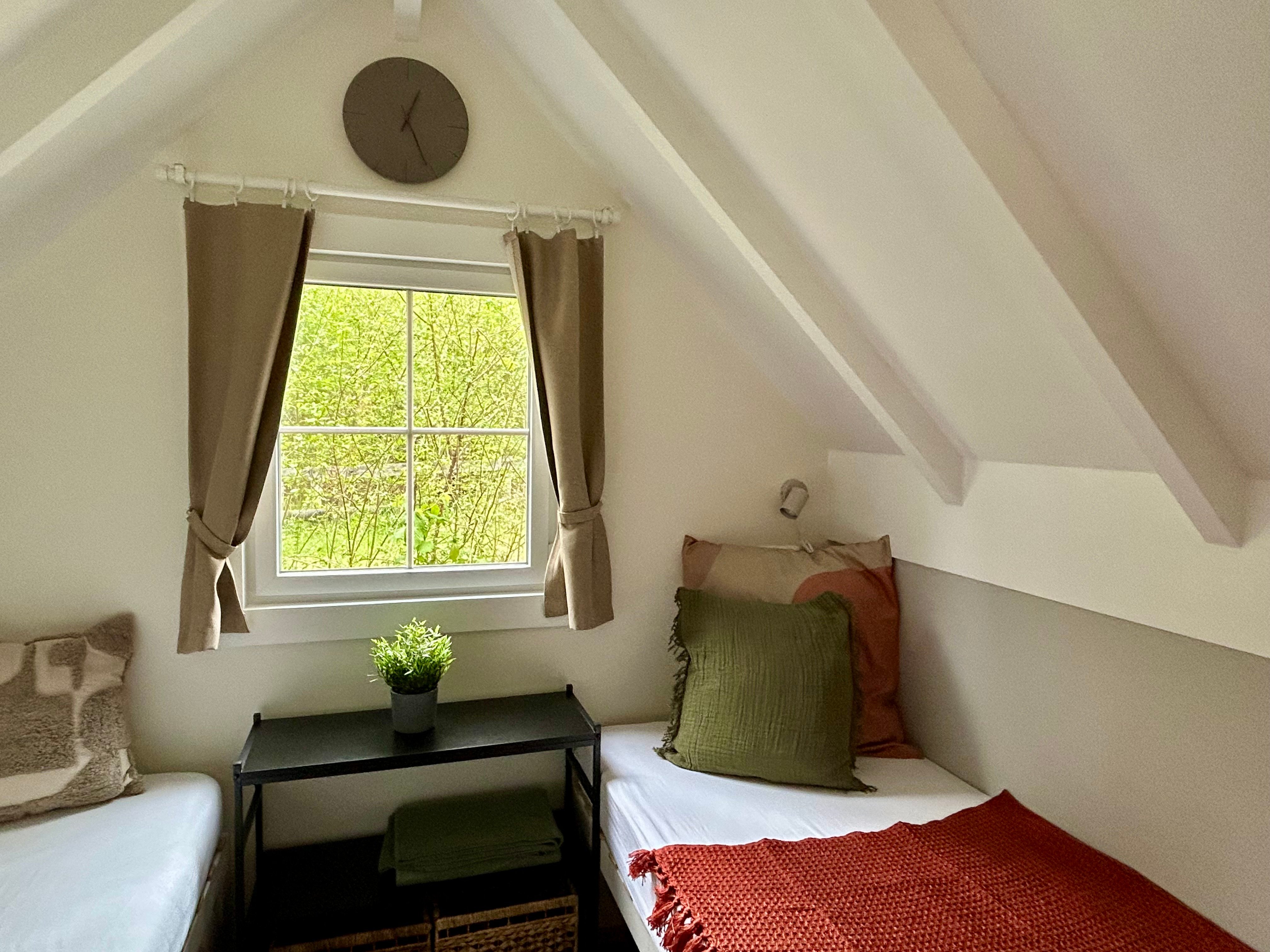 Vue intérieure d'un mini chalet avec deux lits simples.