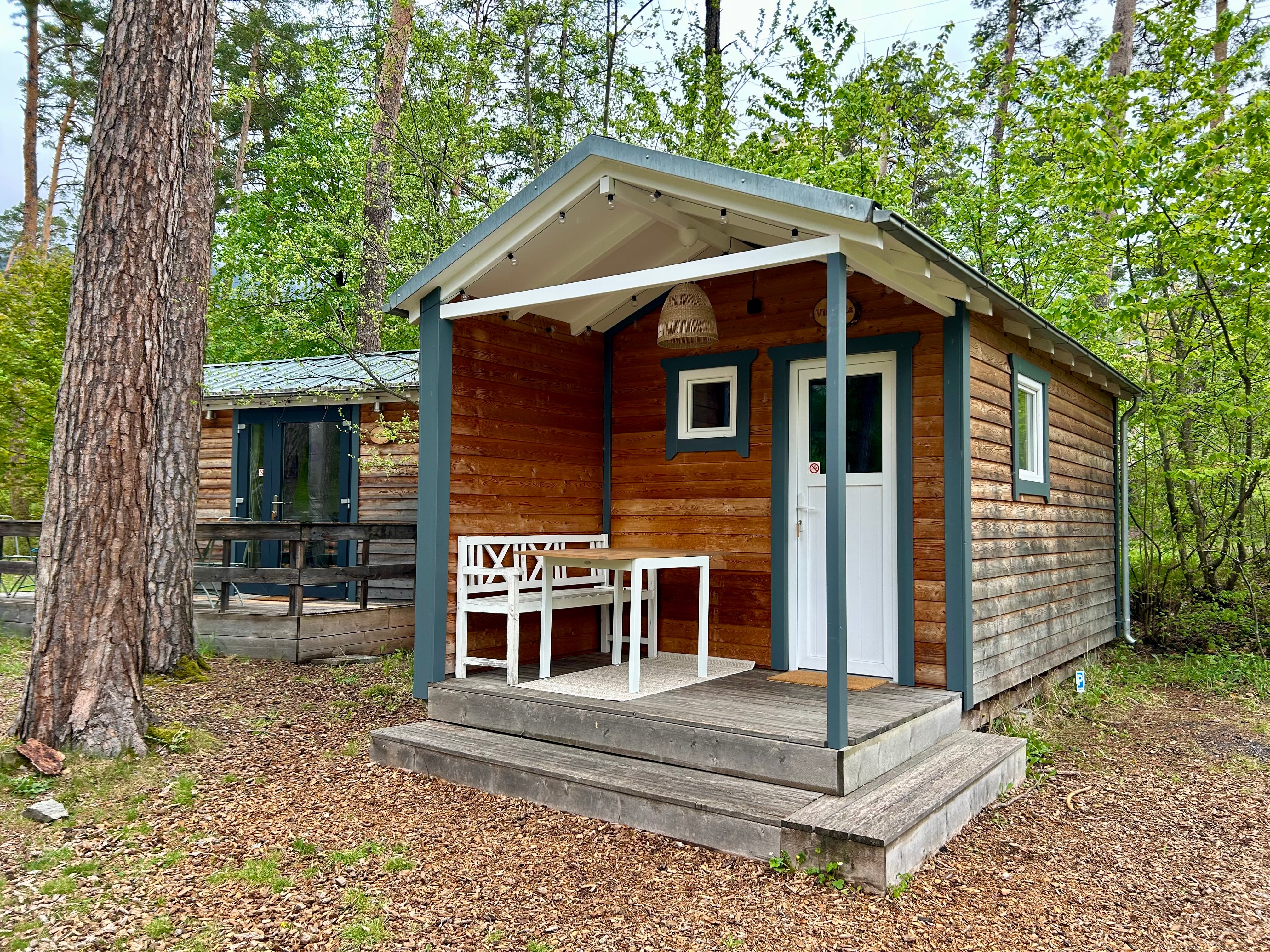 Chalets situés sous les arbres et dotés d'une petite terrasse.