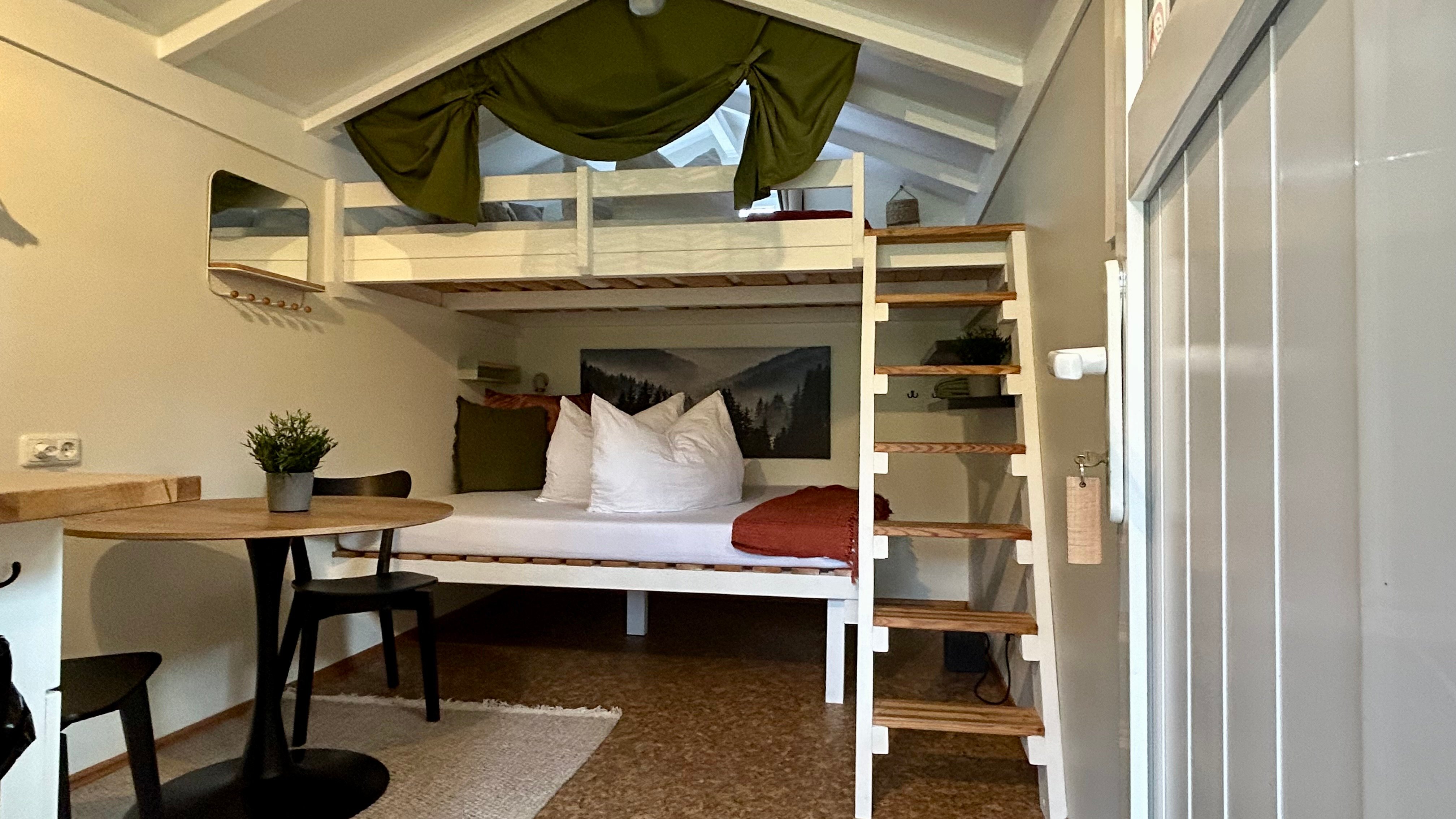 Il y a deux cabines avec des lits doubles dans un petit logement locatif.