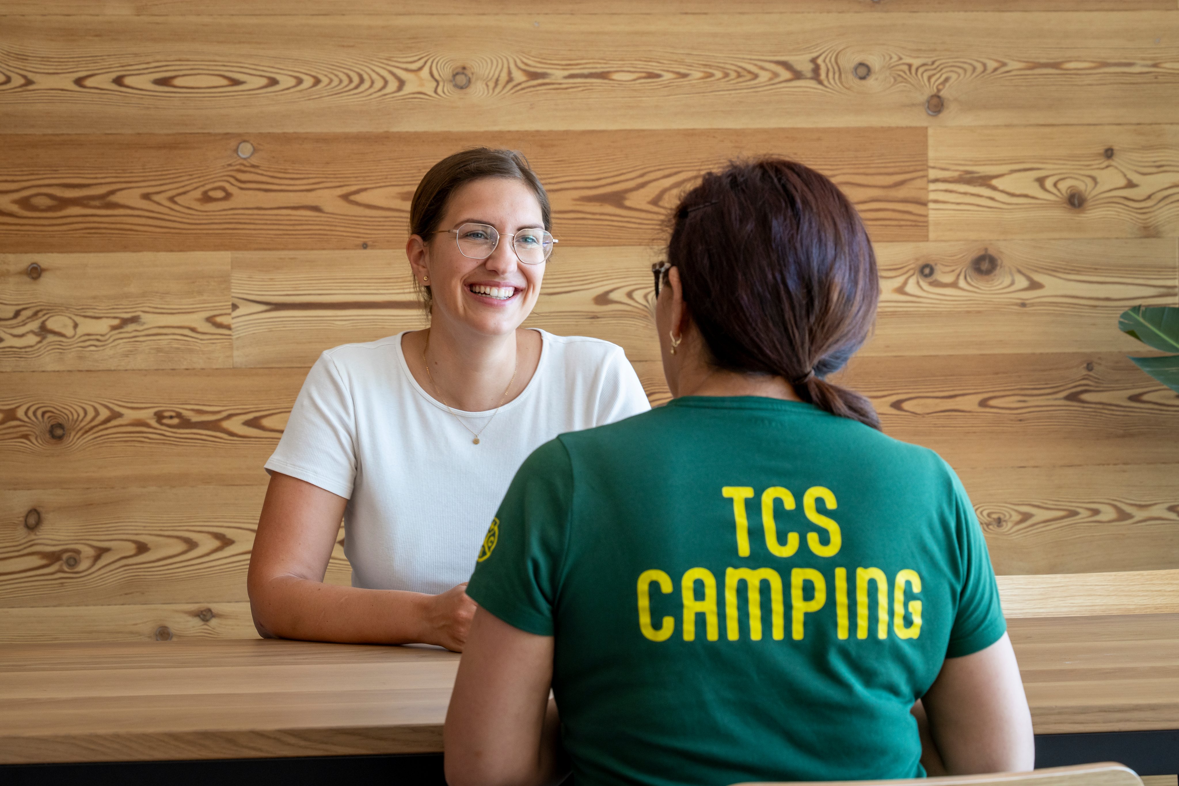 Deux femmes sont assises à une table et se parlent.