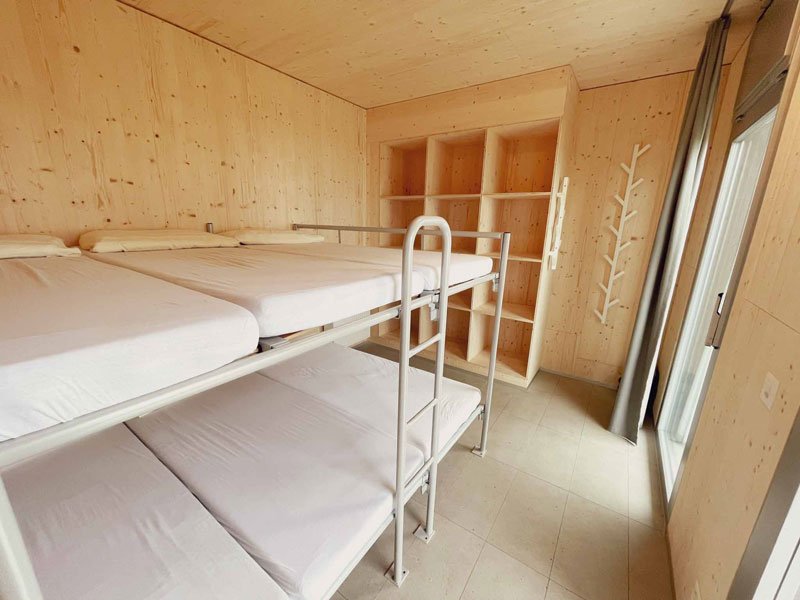 Une chambre moderne avec des lits superposés et beaucoup de bois.