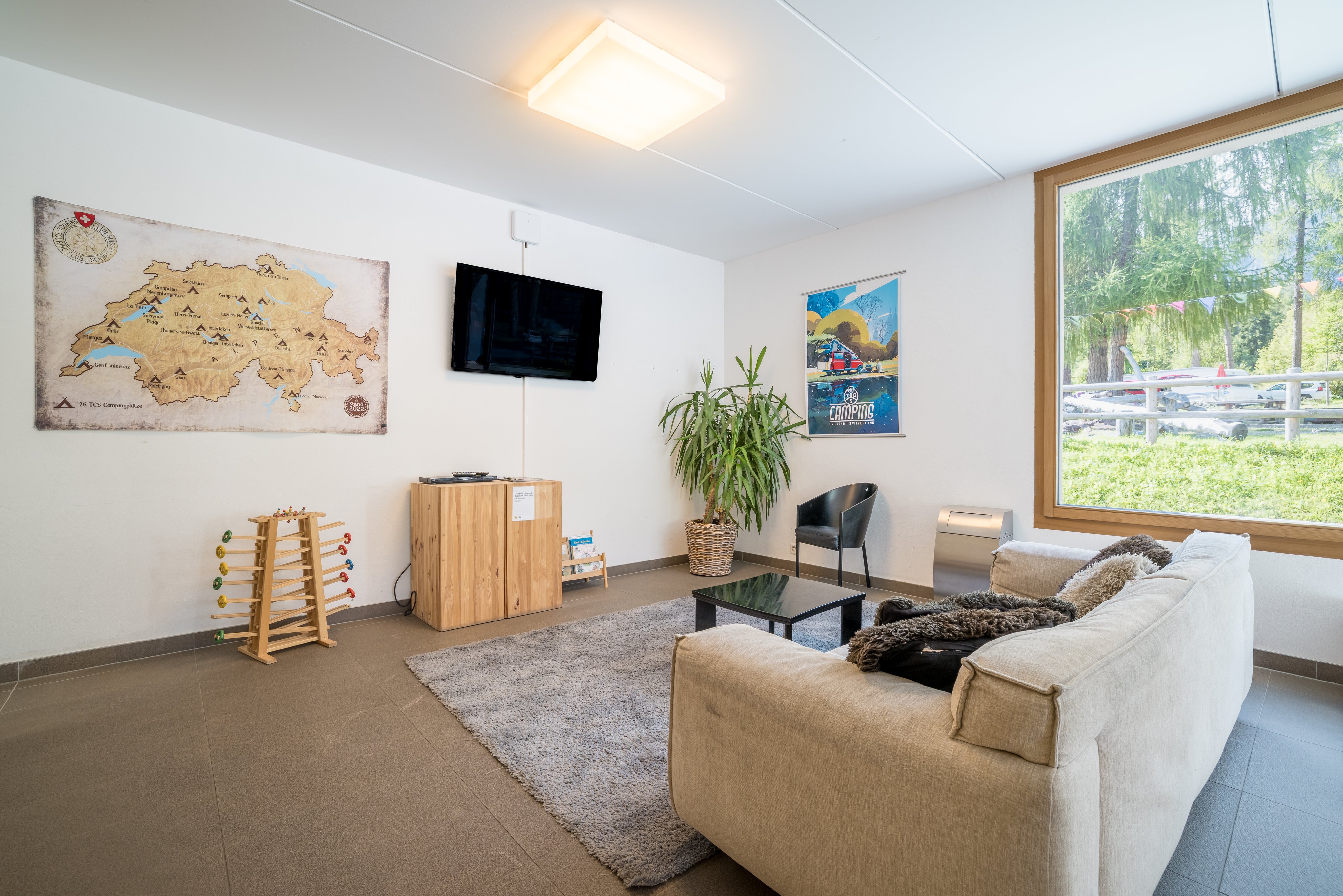 Sala ricreativa in un campeggio con divano, TV e giochi.