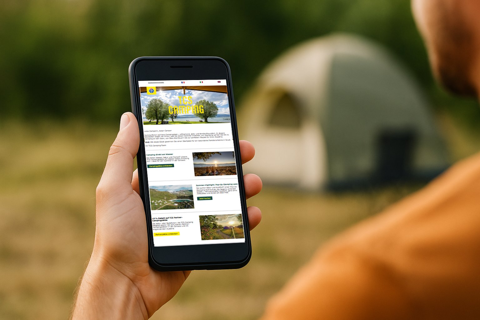 Un homme regarde son smartphone et lit une newsletter sur le camping.