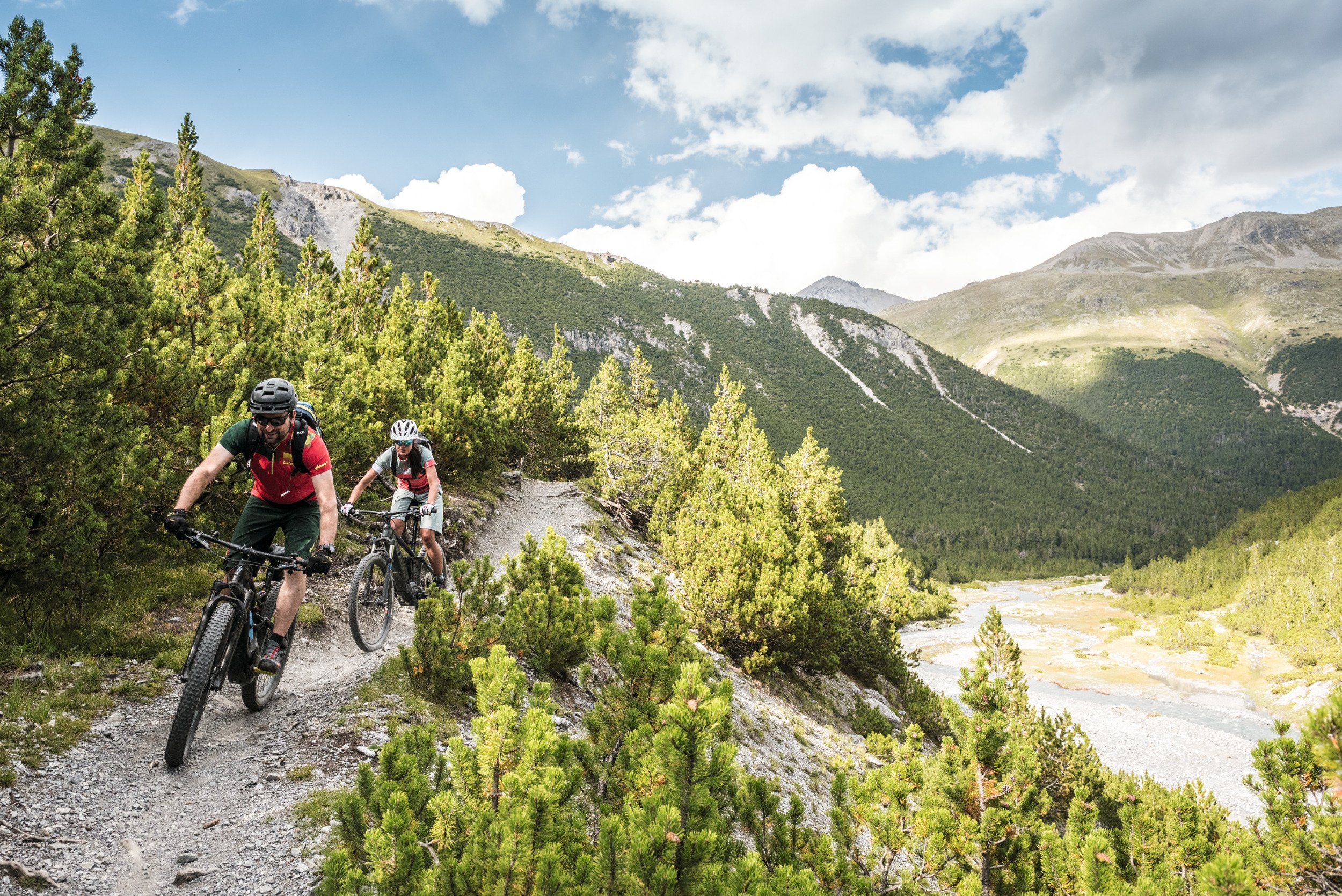 eMountainbiker Paar unterwegs auf einem Single Trail entlang der Aua dal Val Mora.