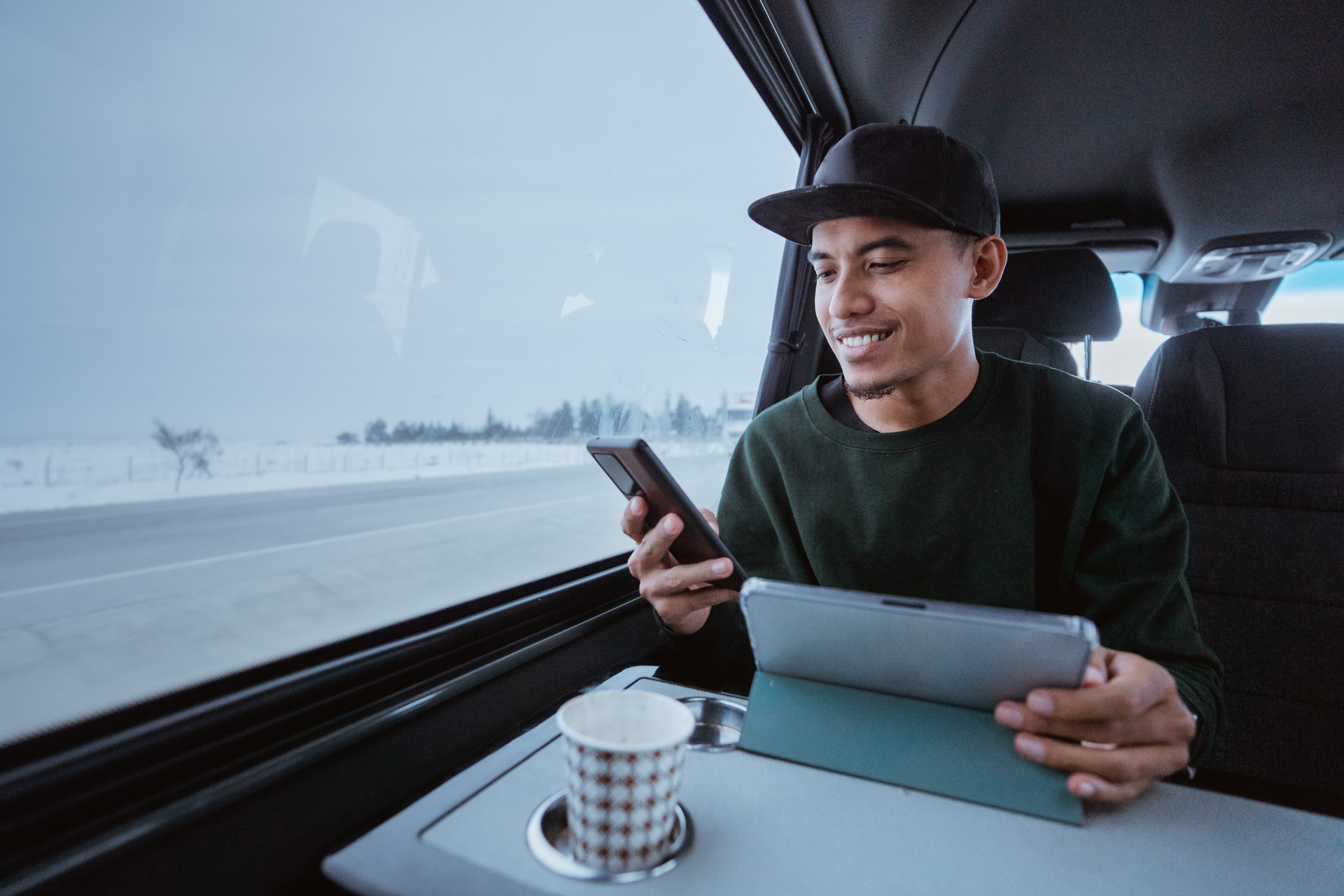Un jeune homme qui travaille tout en voyageant dans un van. 
