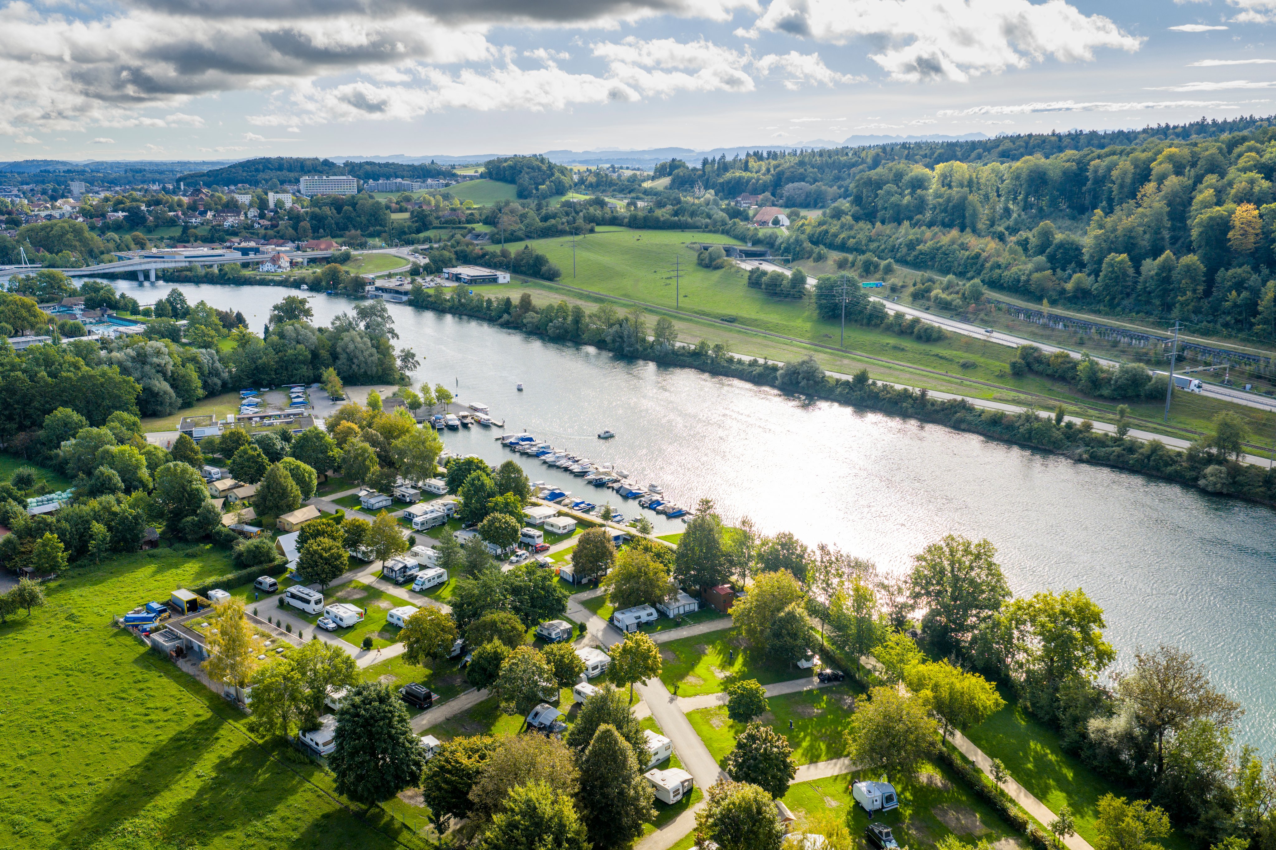 Vue aérienne du camping TCS de Soleure avec l'Aar et la forêt.