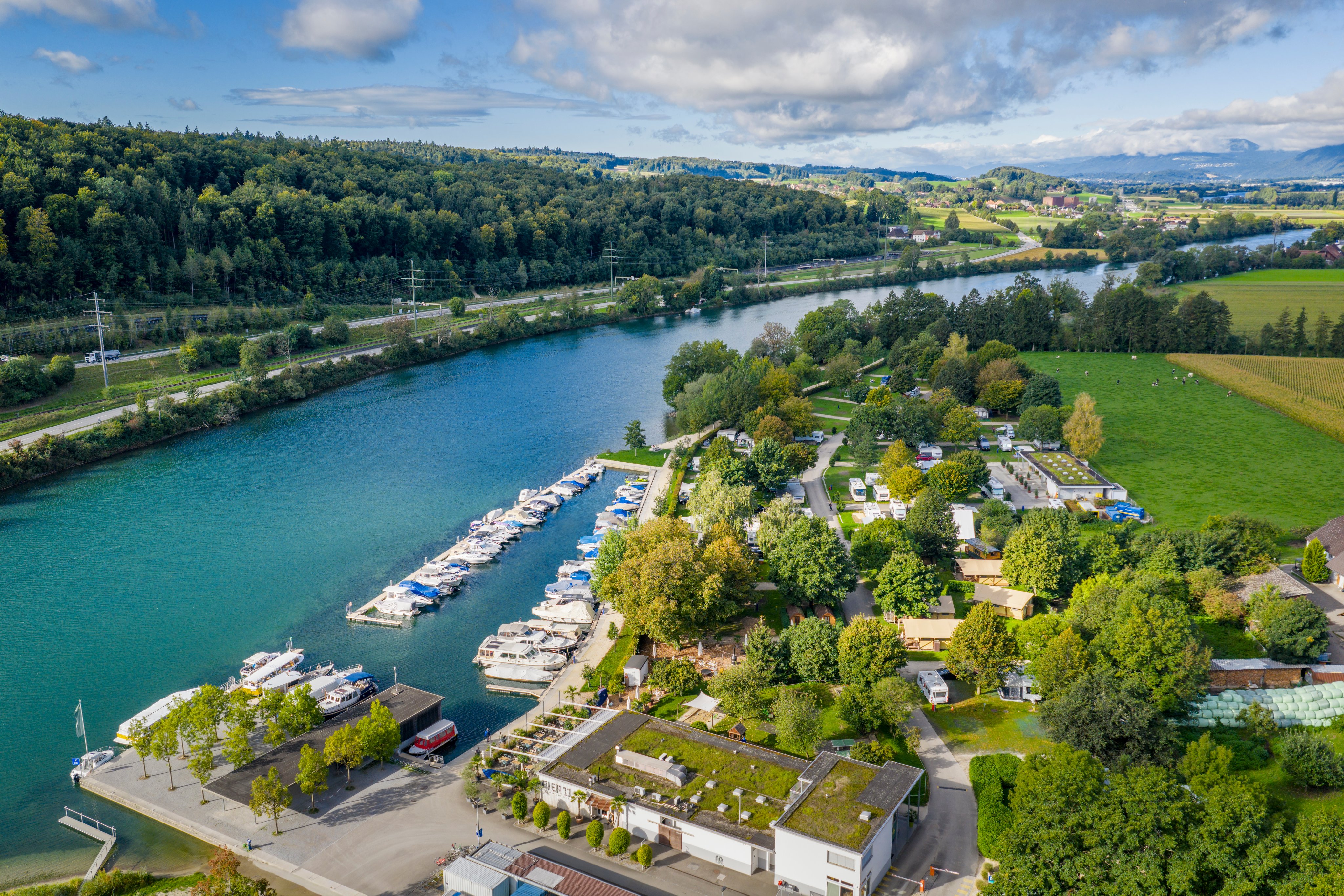 Luftaufnahme vom TCS Camping Solothurn mit dem Restaurant Pier11, Bootsanlegestelle sowie der Umgebung.