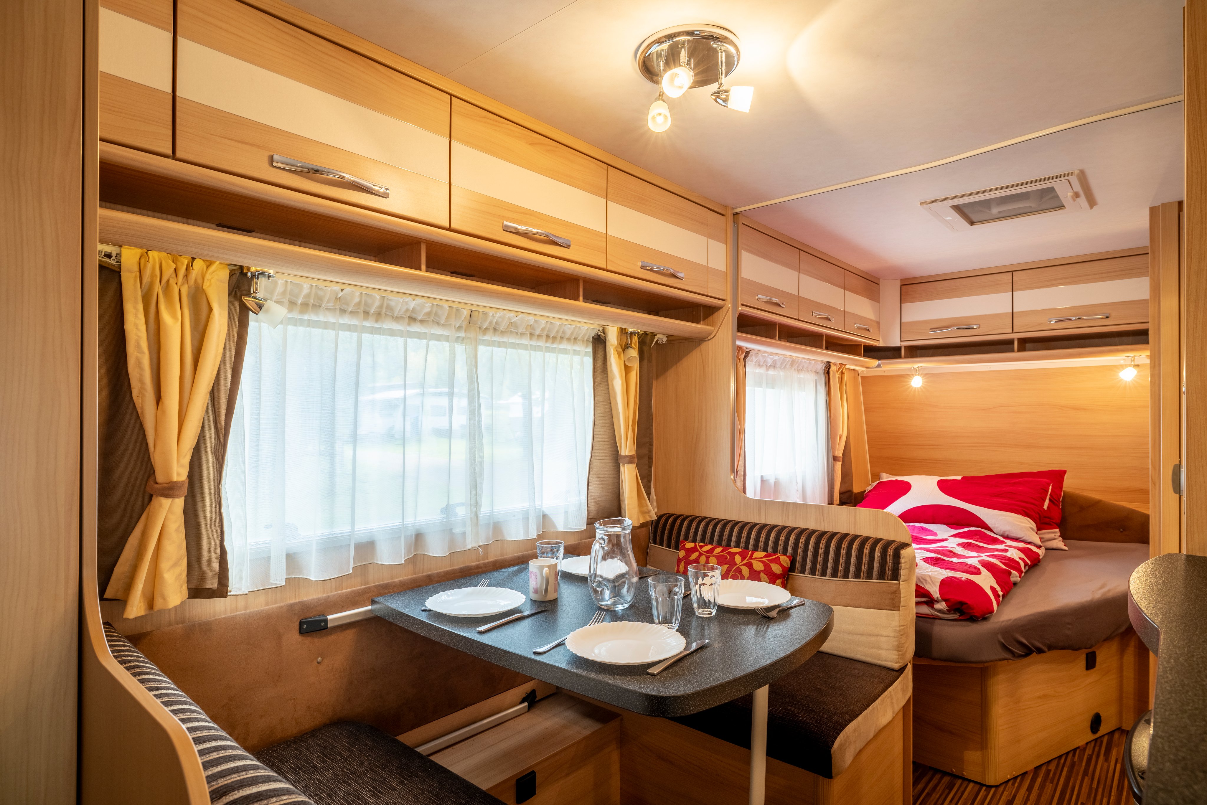 Une caravane dispose d'un lit et d'une table à l'intérieur.