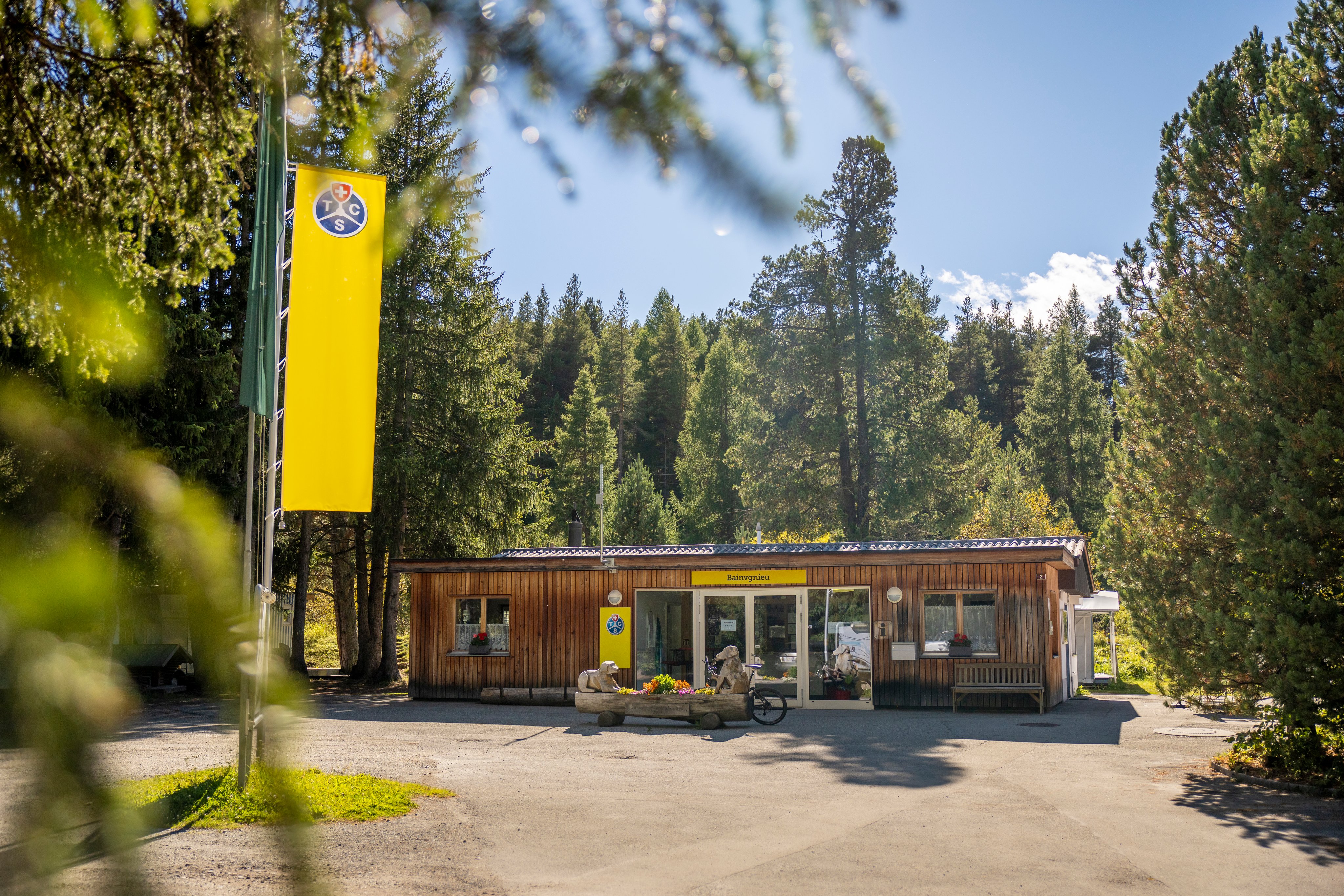 Eingangsbereich eines Campings mit dem Receptionsgebäude und den Fahnen.