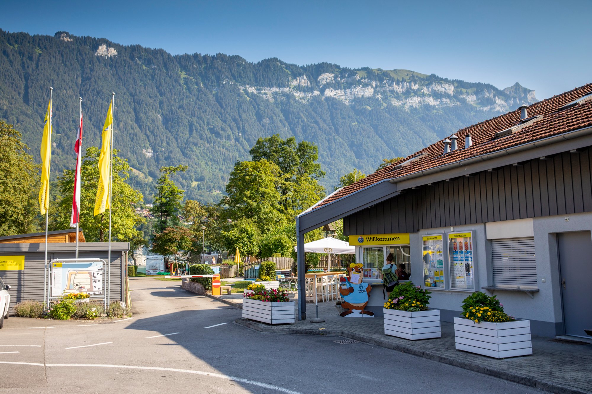 Entrance to a campsite with mountains in the background.