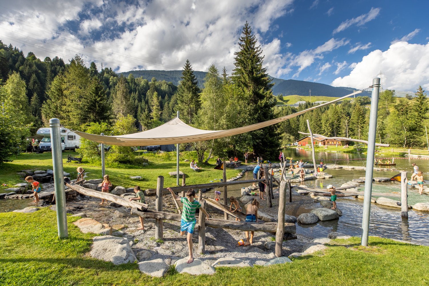 Children on the water playground at TCS Camping Disentis.