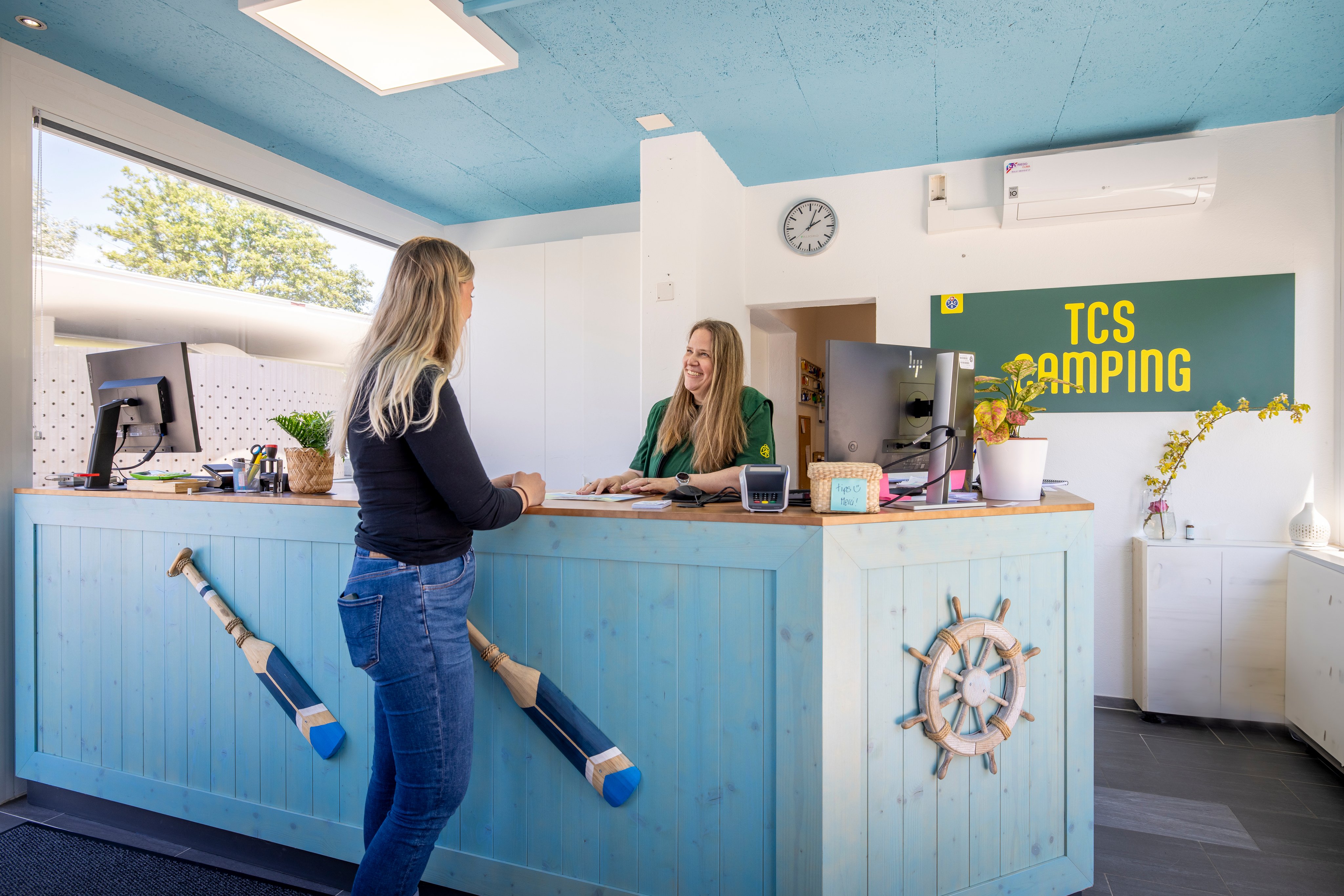 Deux femmes à la réception d'un camping.