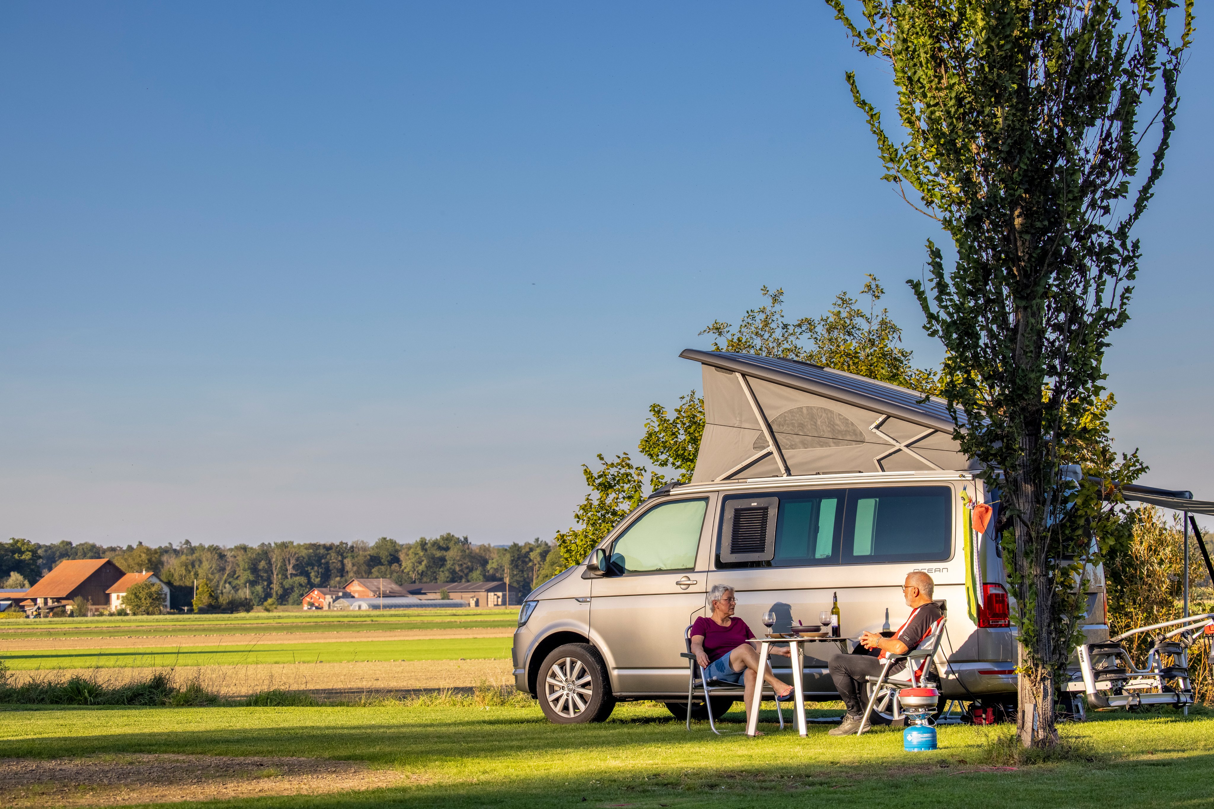 Feriengäste am Abendessen auf einem Stellplatz des TCS Camping Flaach am Rhein
