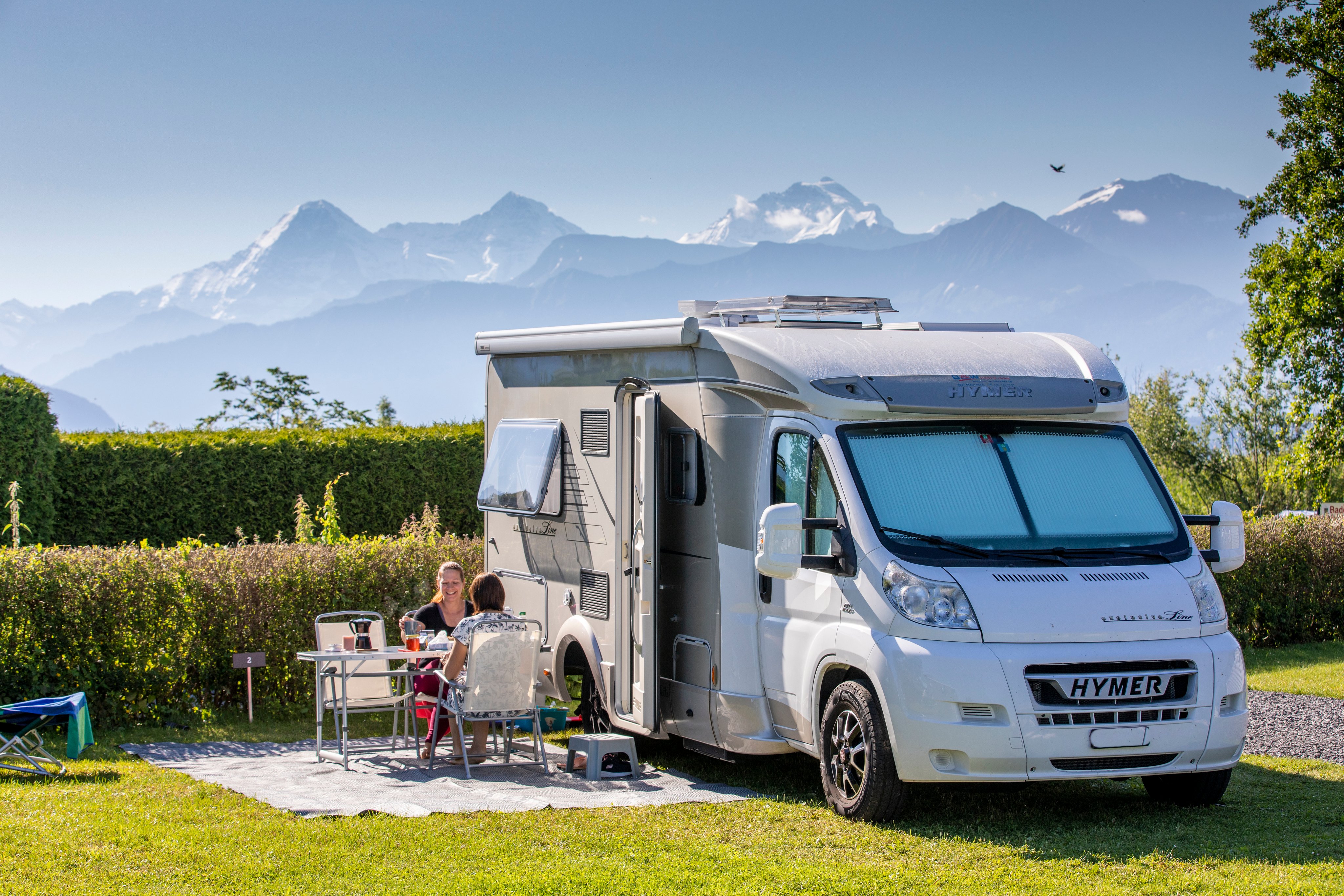 Camper at TCS Camping Gwatt Thunersee with mountains in the background.