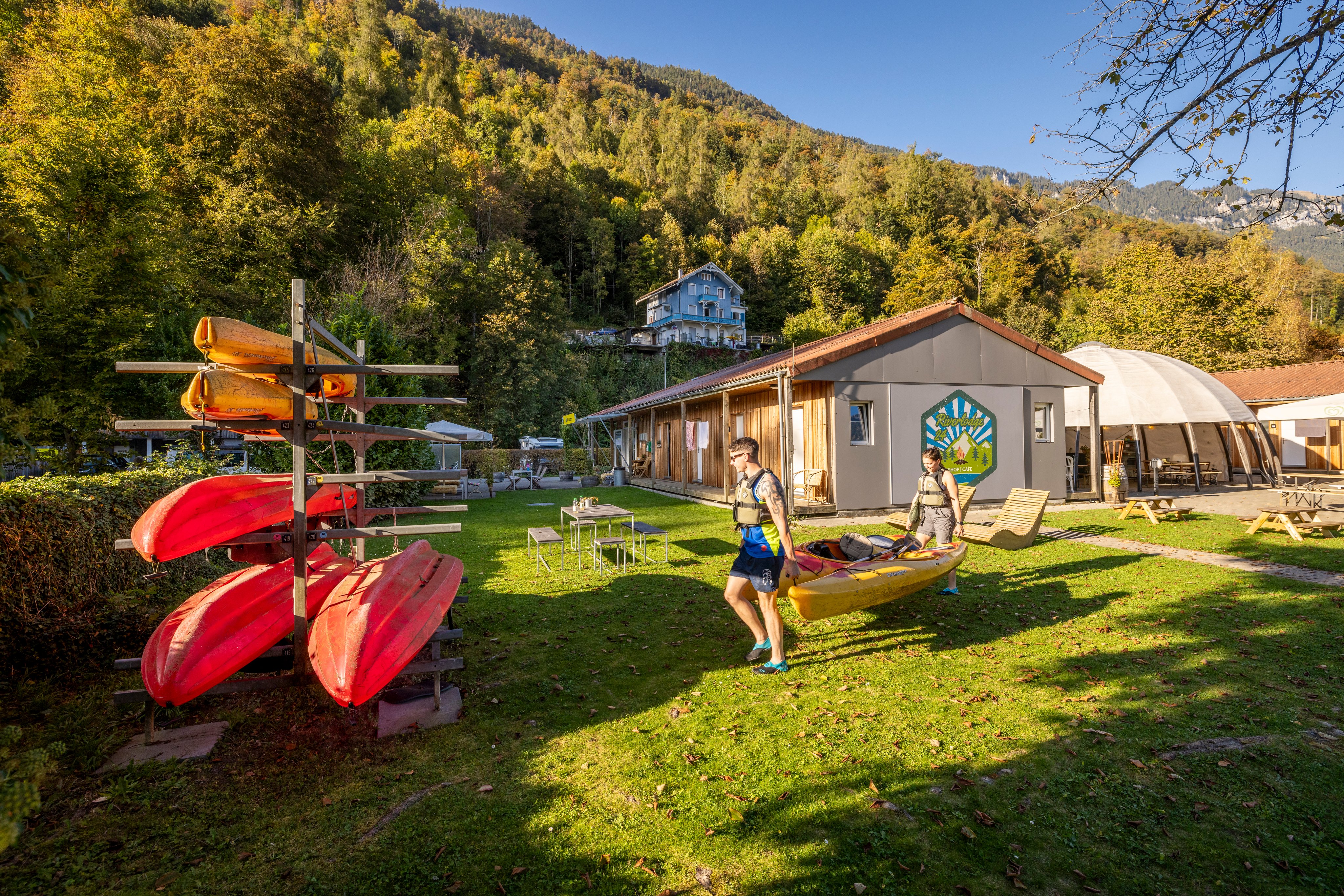 Deux personnes portent deux canoës.