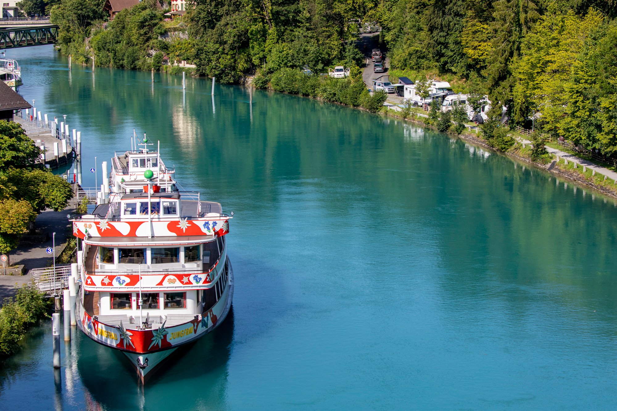 Un bateau sur une rivière à côté d'un camping.