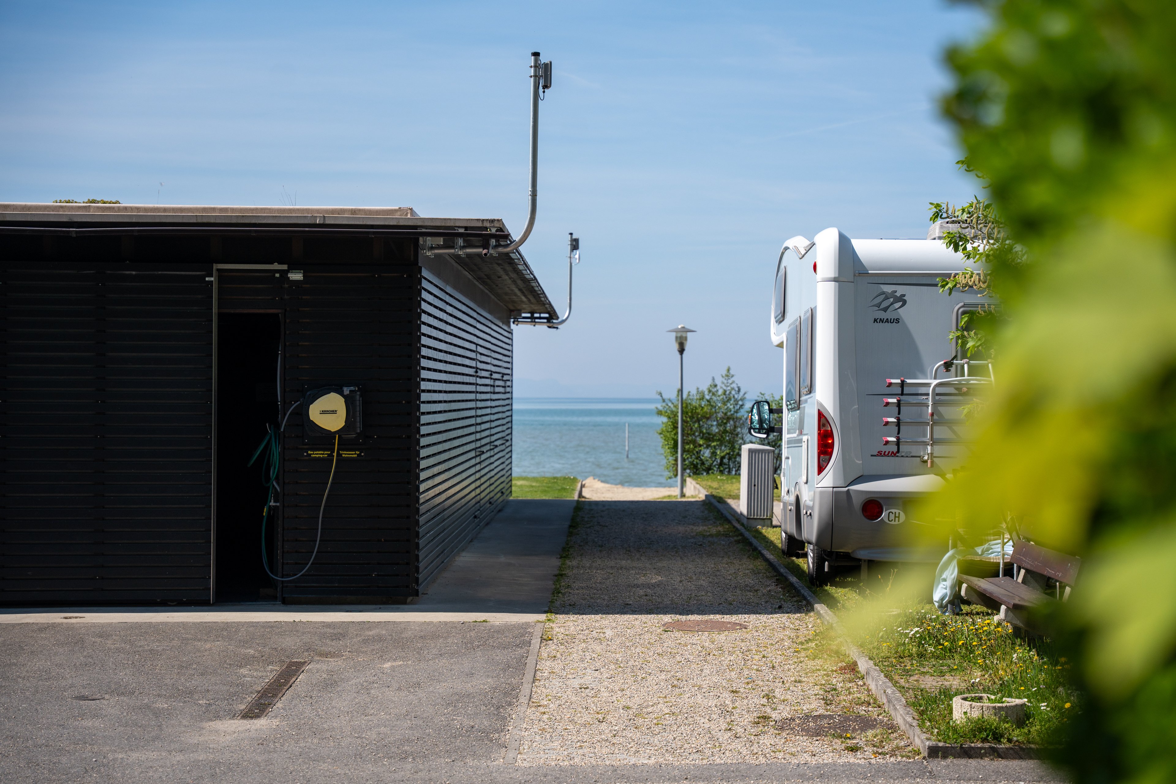 Ein Camper steht auf einem Campingplatz am See.