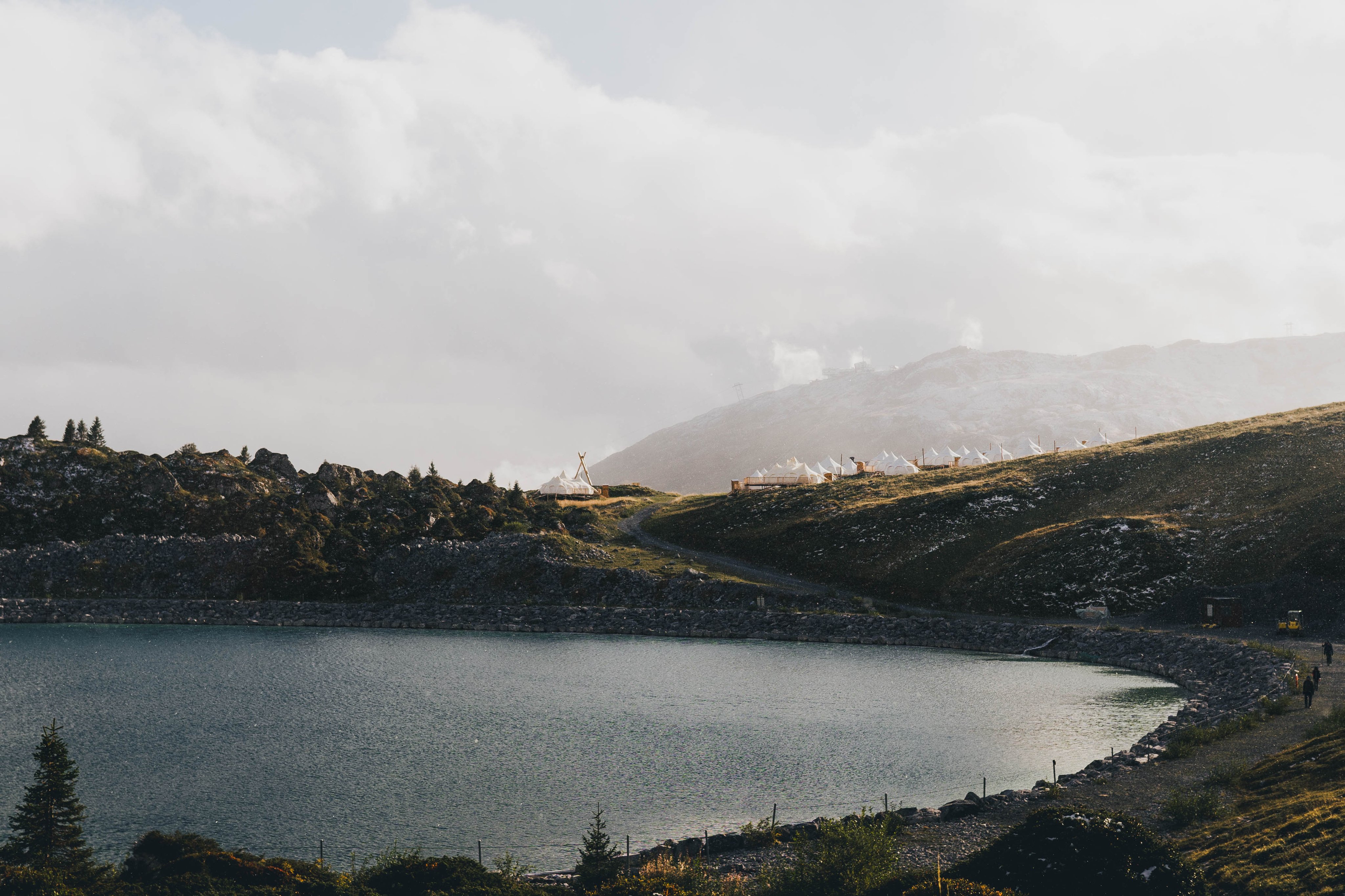 Il Pop Up Glamping si trova in mezzo alle montagne, con vista sul lago in lontananza.